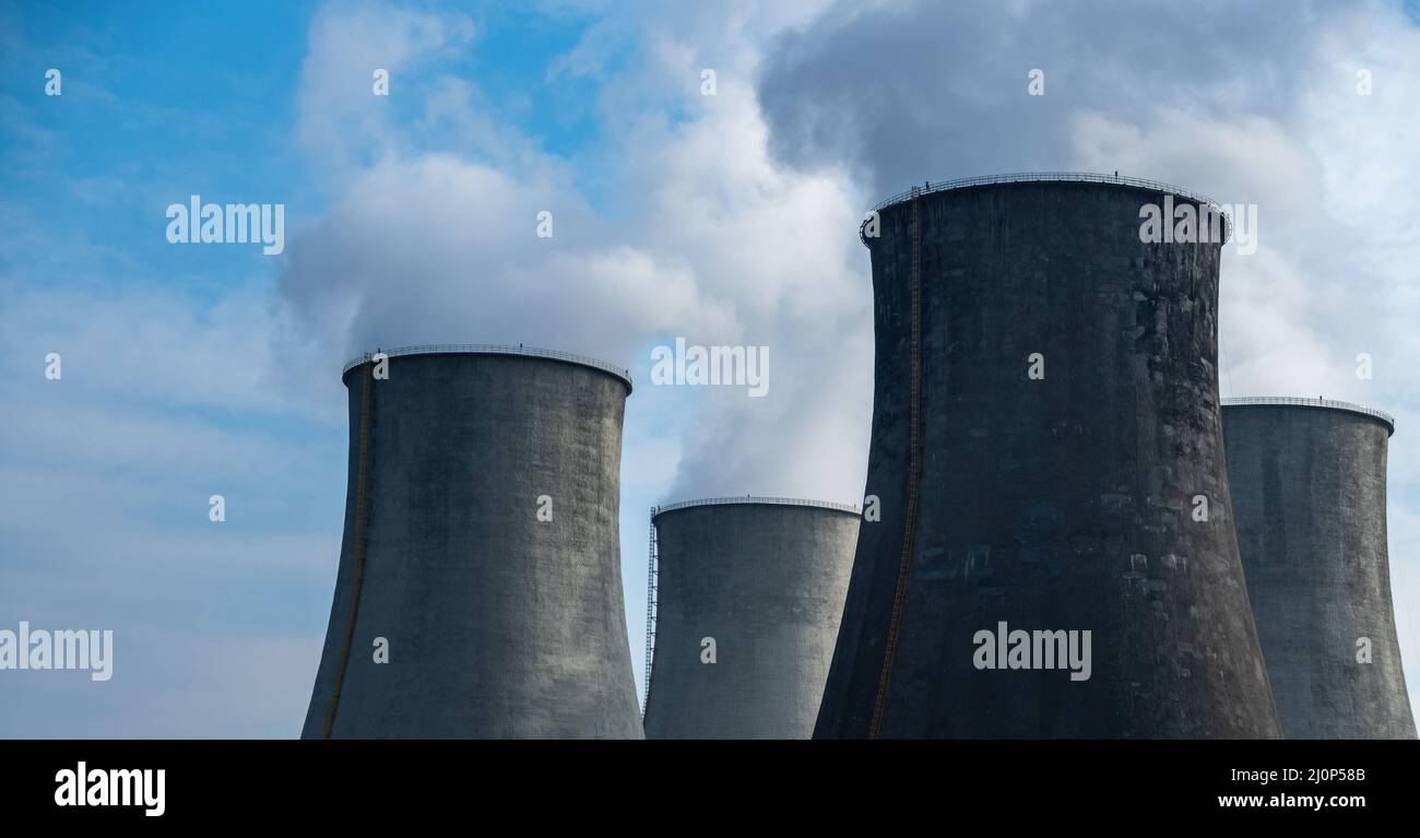 Primo piano del vapore in uscita dalle torri di raffreddamento di una centrale a carbone. Foto scattata in una giornata di sole, illuminazione a contrasto. Foto Stock