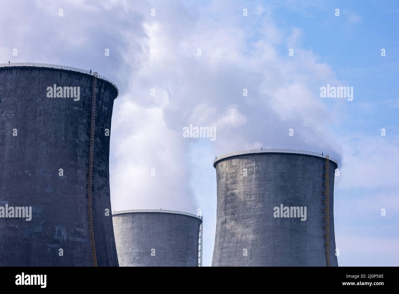 Primo piano del vapore in uscita dalle torri di raffreddamento di una centrale a carbone. Foto scattata in una giornata di sole, illuminazione a contrasto. Foto Stock