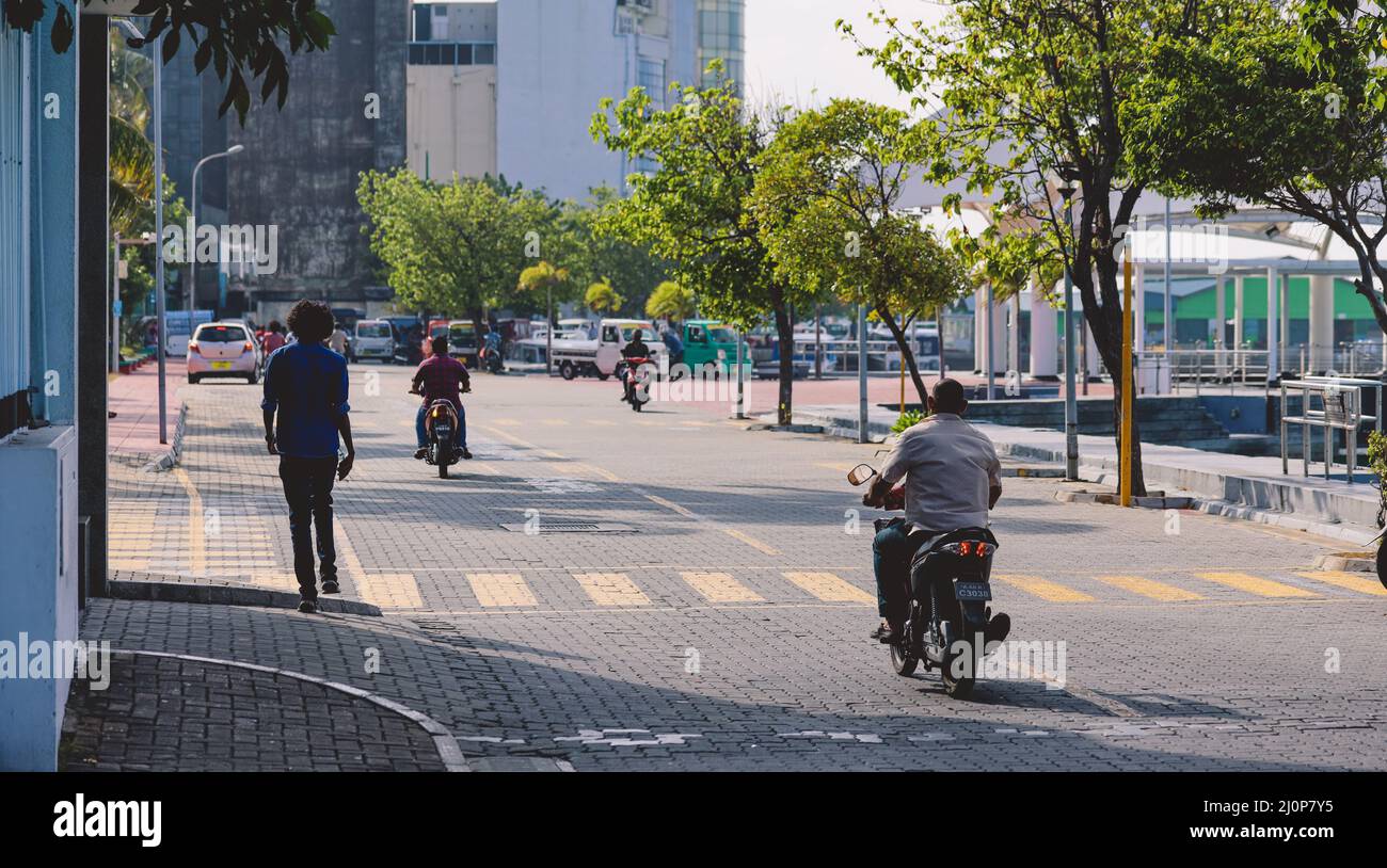 Maldivian gente locale che guida sulle bici sulle strade della città di Male Foto Stock