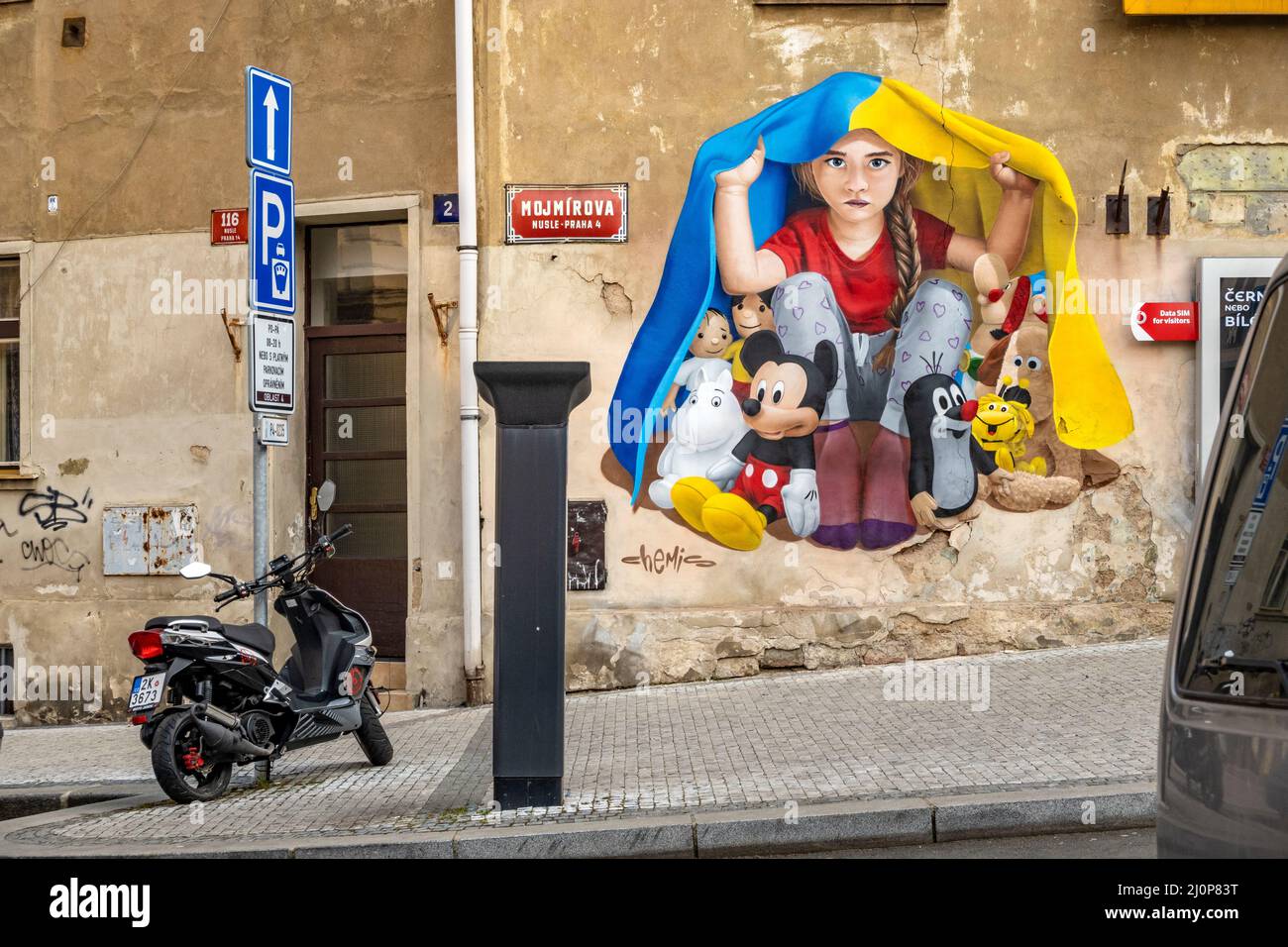 Una ragazza che prende rifugio sotto una bandiera Ucraina, murale arte di ChemiS (artista ceco con radici kazake, Dmitry Proshkin), Nusle, Praga, repubblica Ceca Foto Stock