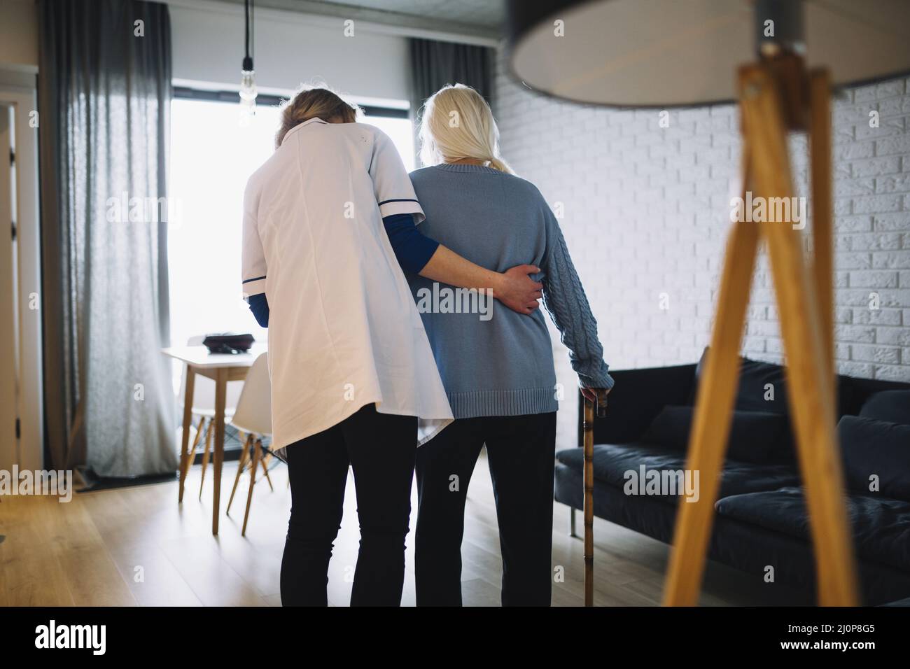 Donna che cammina con l'infermiera di vecchiaia a casa. Alta qualità e risoluzione bellissimo concetto di foto Foto Stock