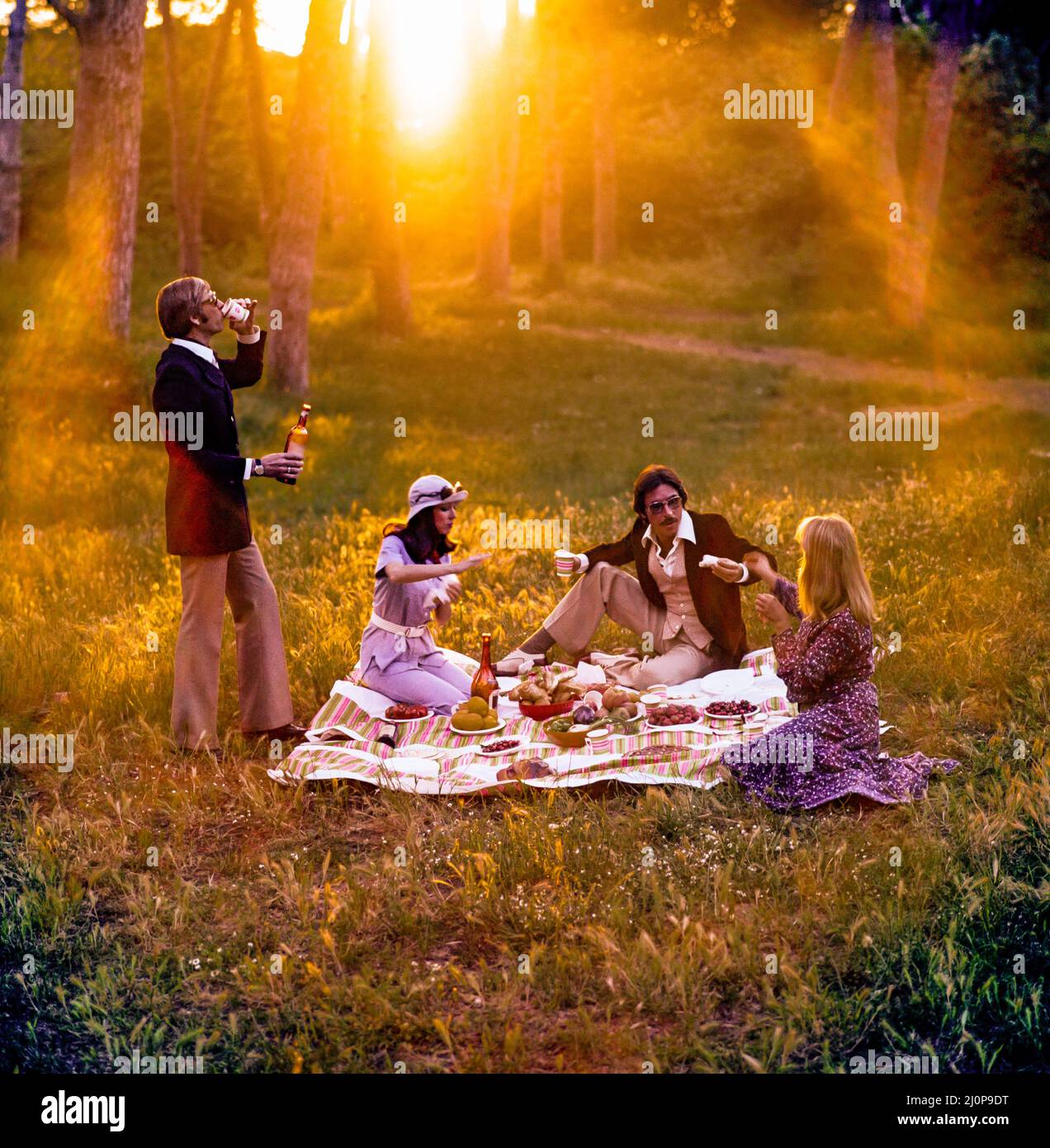 Vintage Italy 1970s, 2 coppie di amici allegri che fanno un picnic al tramonto, luce solare, tardo pomeriggio, Campagna romana, Lazio, Europa, Foto Stock