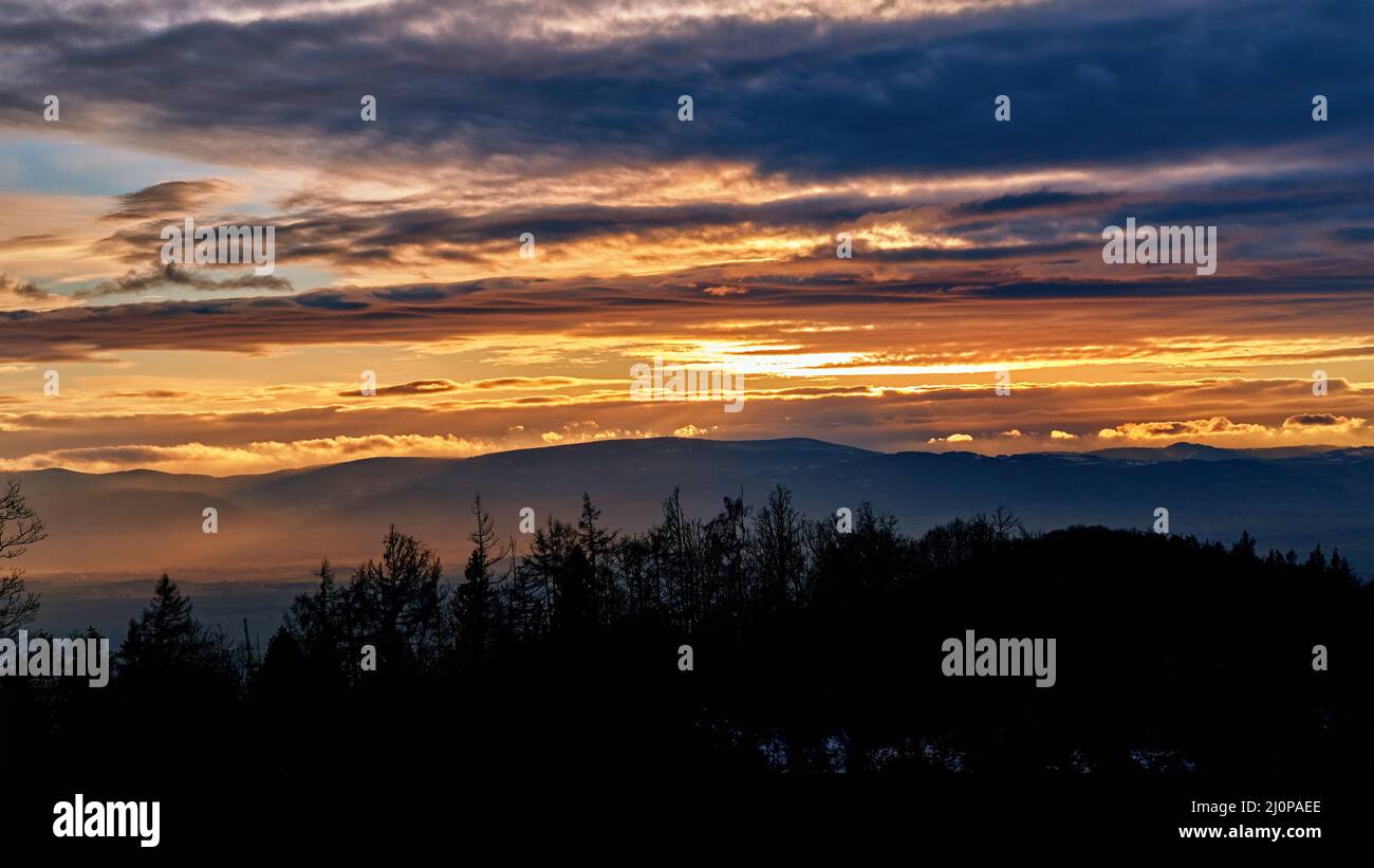 Tramonto con il cielo nuvoloso drammatico sopra le montagne forma, bellissimo paesaggio naturale Foto Stock