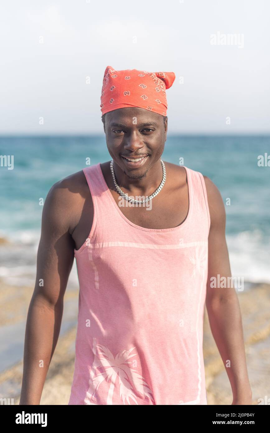 uomo in t-shirt rosa con spiaggia sullo sfondo Foto Stock