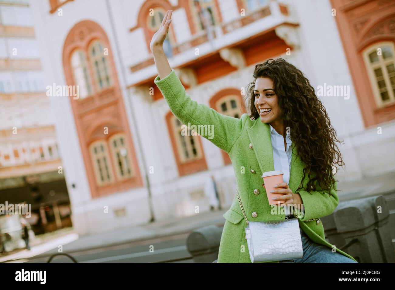 Bella giovane donna in strada che tiene takeaway caffè Foto Stock