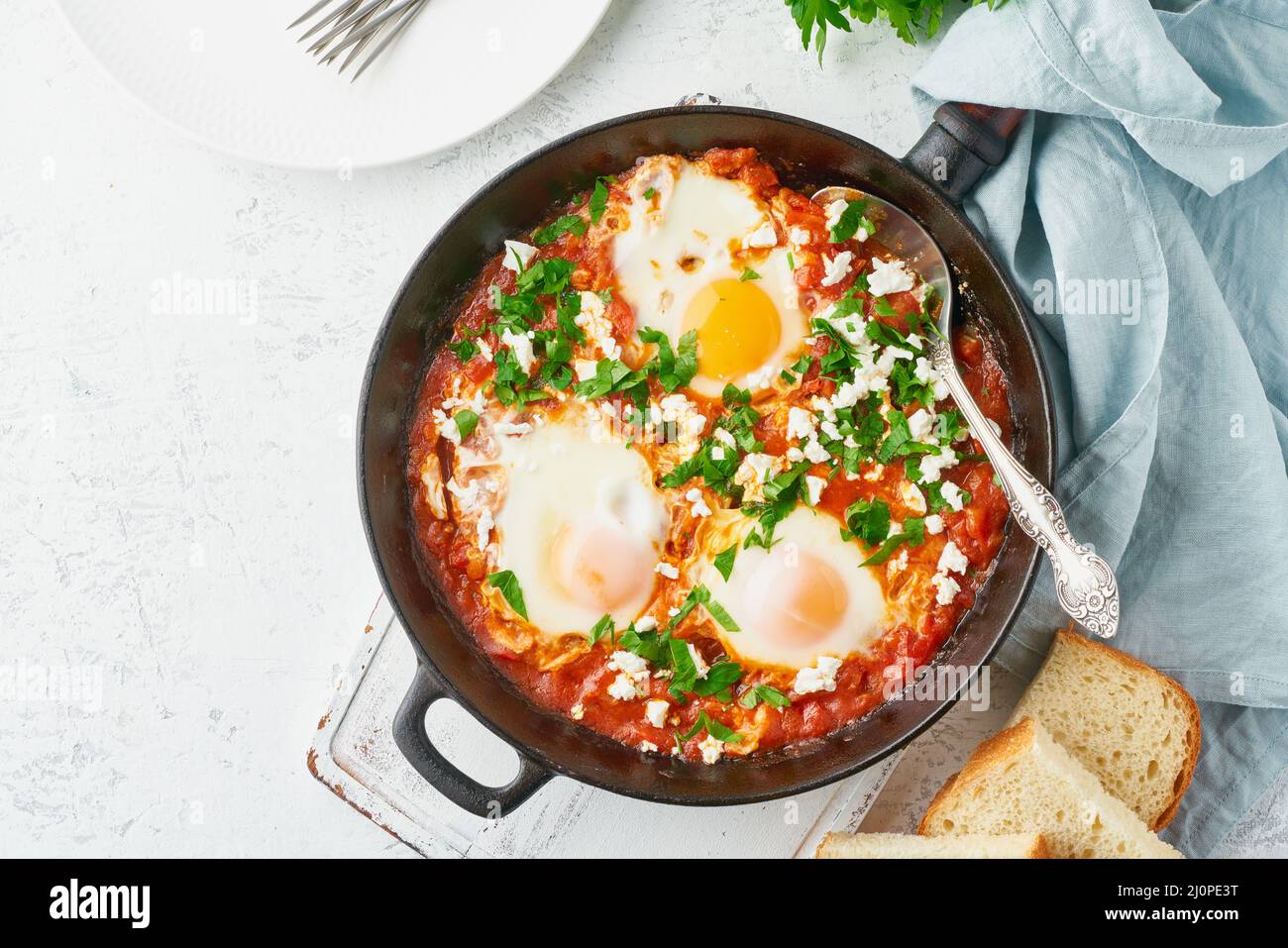 Shakshouka, uova in camicia in salsa di pomodori, olio d'oliva. Cucina mediterranea. Foto Stock