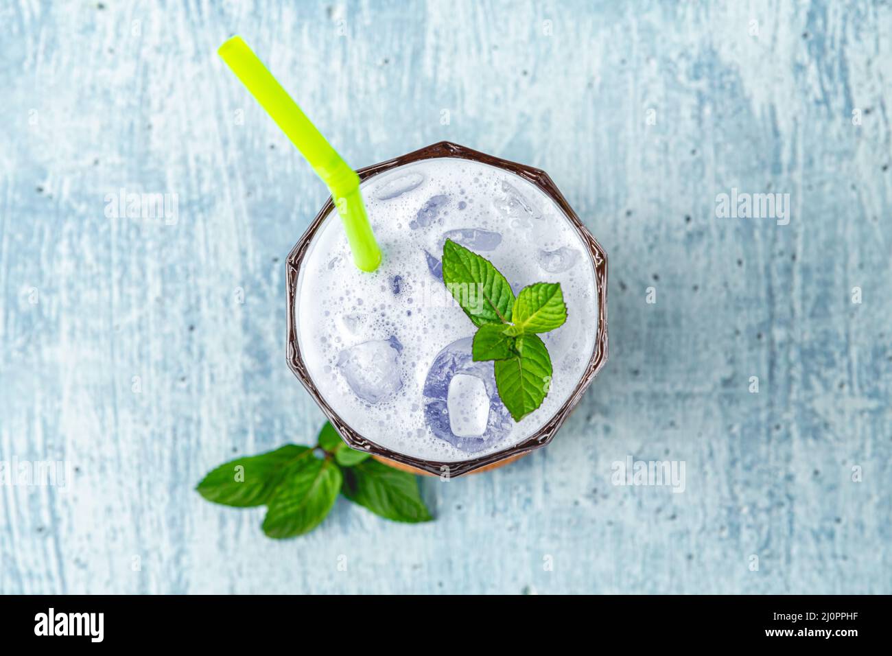 rinfrescante cocktail di cocco blu su sfondo di pietra blu Foto Stock