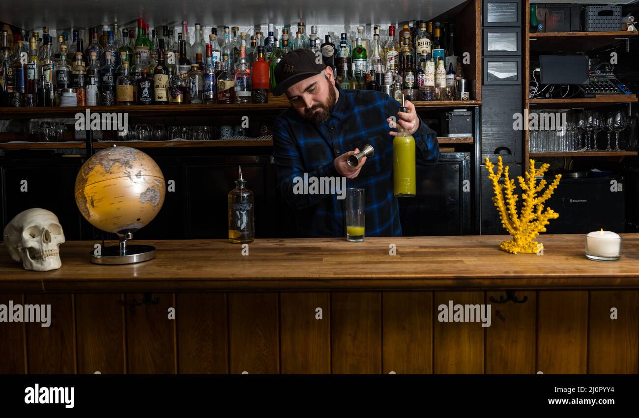 Barista maschile che fa cocktail di frutta al bar, Edimburgo, Scozia, Regno Unito Foto Stock