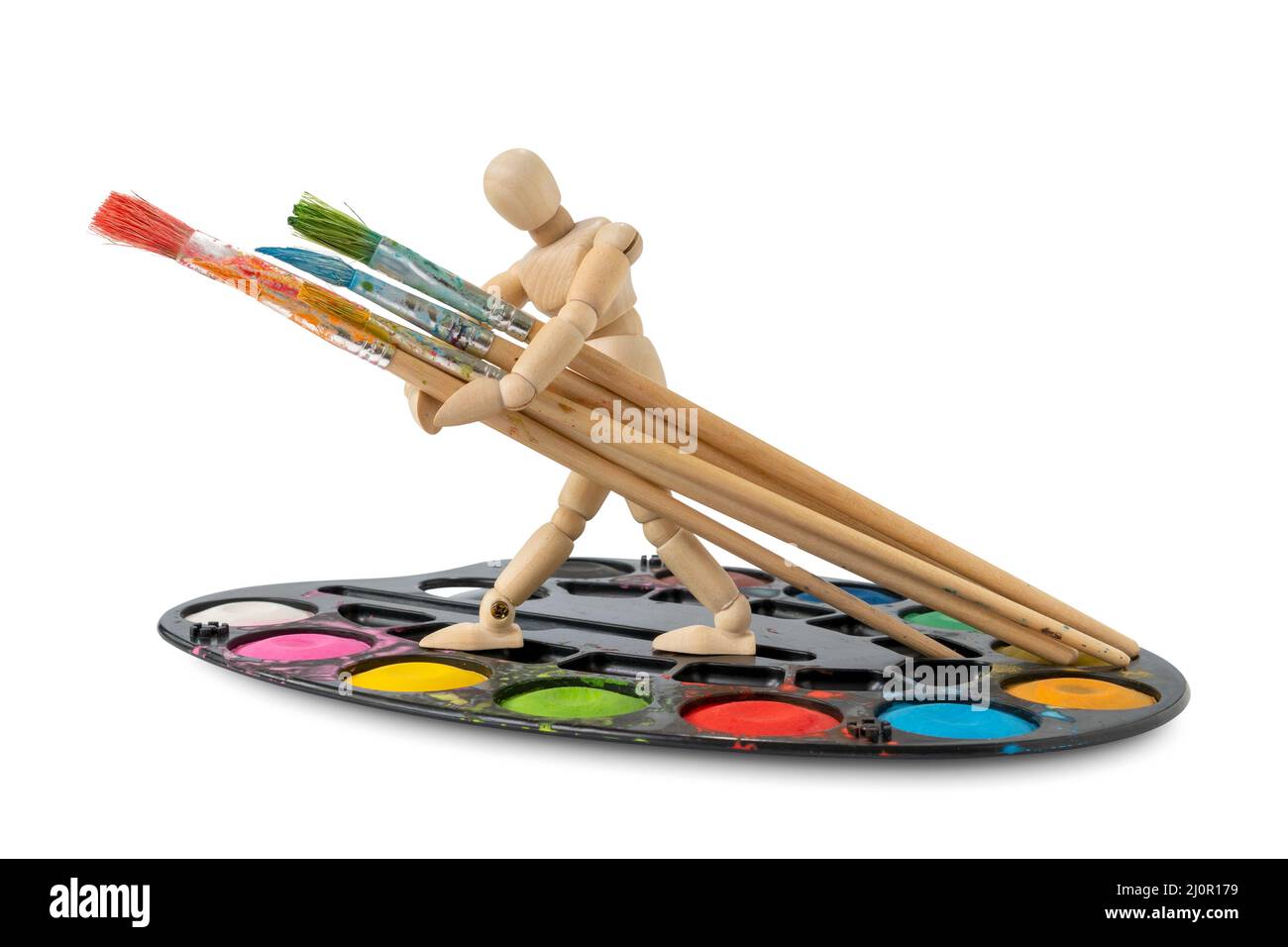Uomo di legno in piedi sulla tavolozza di acquerelli e tenendo pennelli Foto Stock