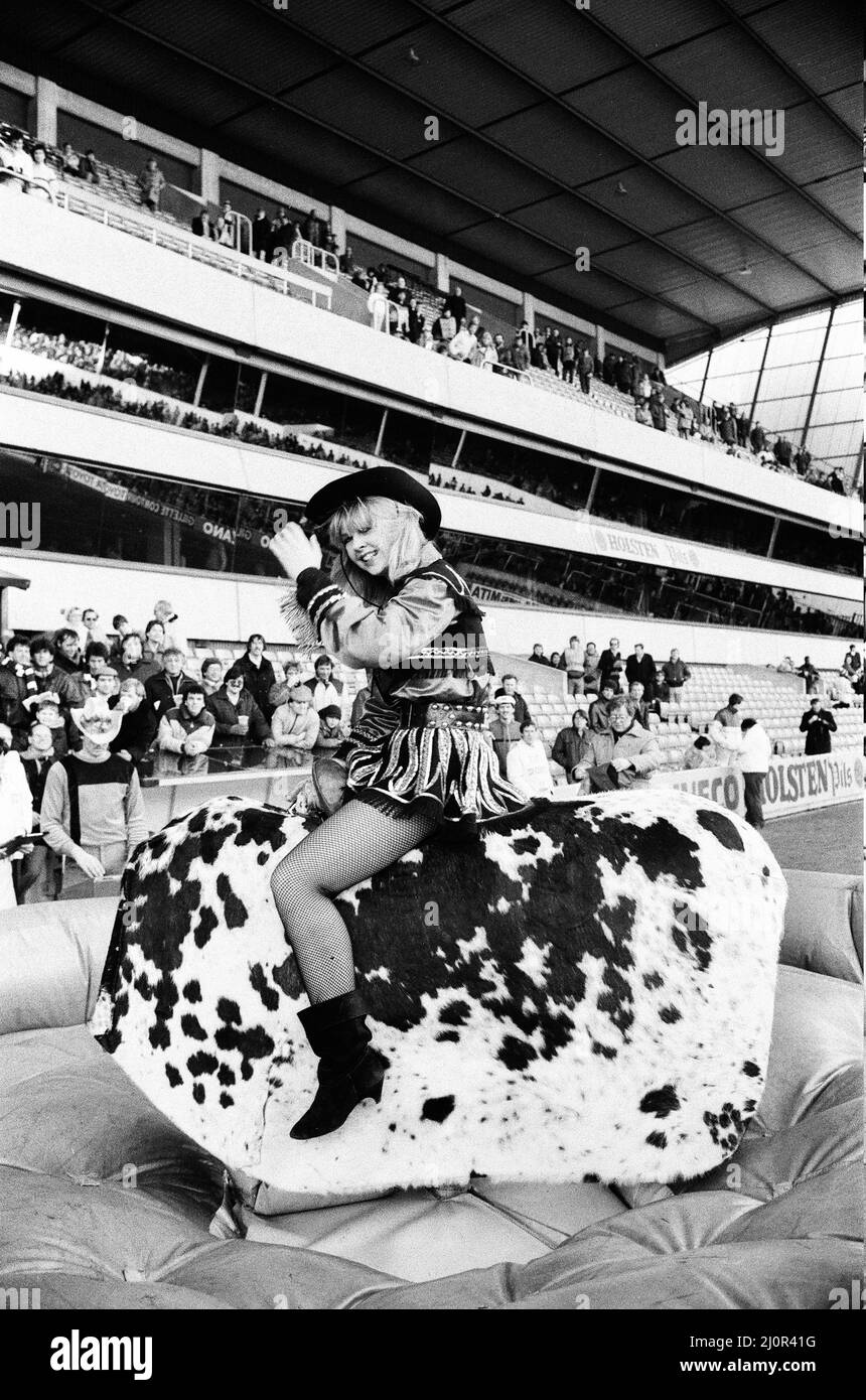 Tottenham Hotspur v Ipswich Town League match at White Hart Lane January 1984. Cowgirl offre intrattenimento pre-partita sulla macchina bucking bronco rodeo bull. Punteggio finale: Tottenham Hotspur 2-0 Ipswich Town Foto Stock