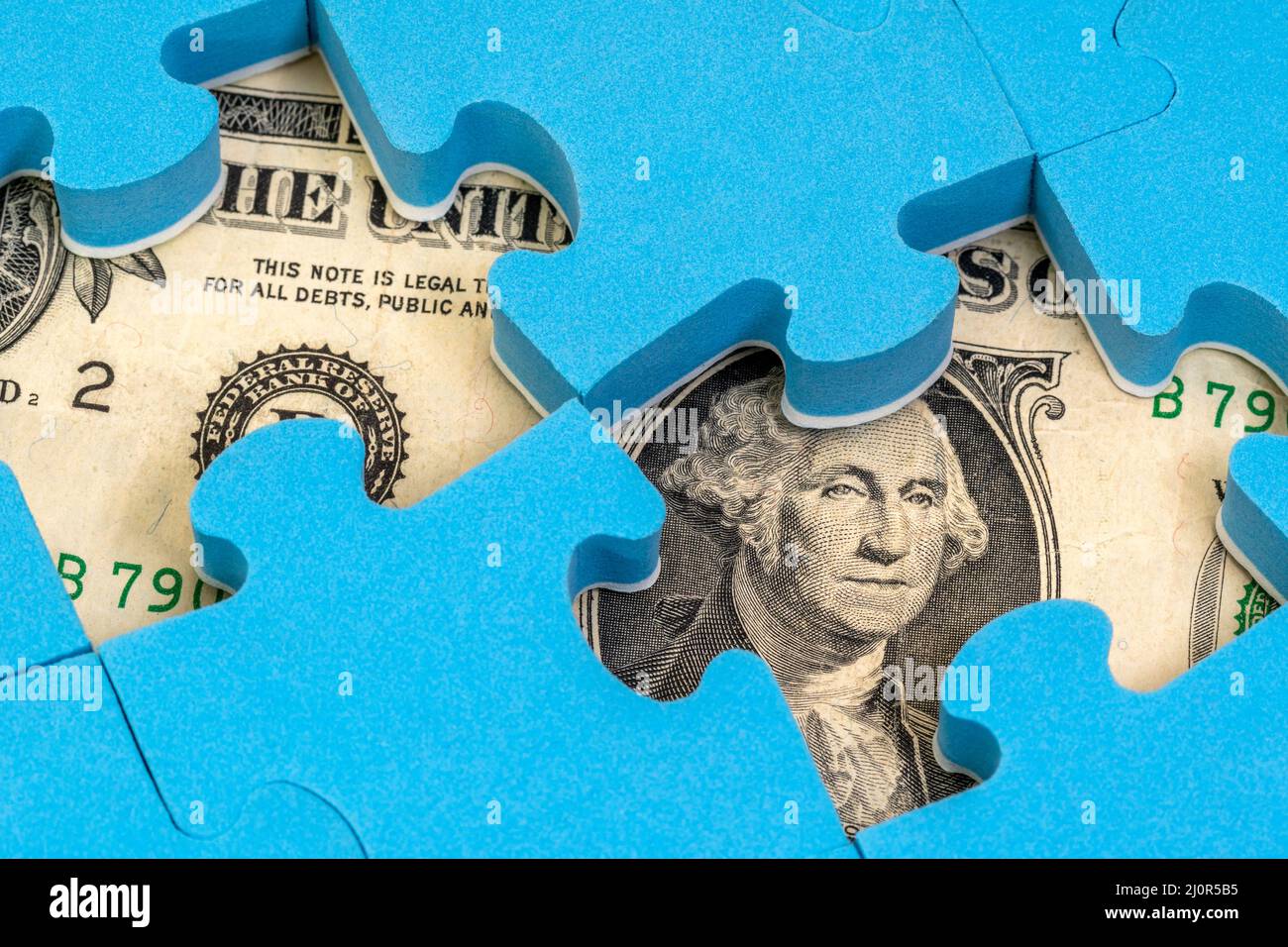 Valuta del dollaro US nascosta sotto il puzzle Foto Stock