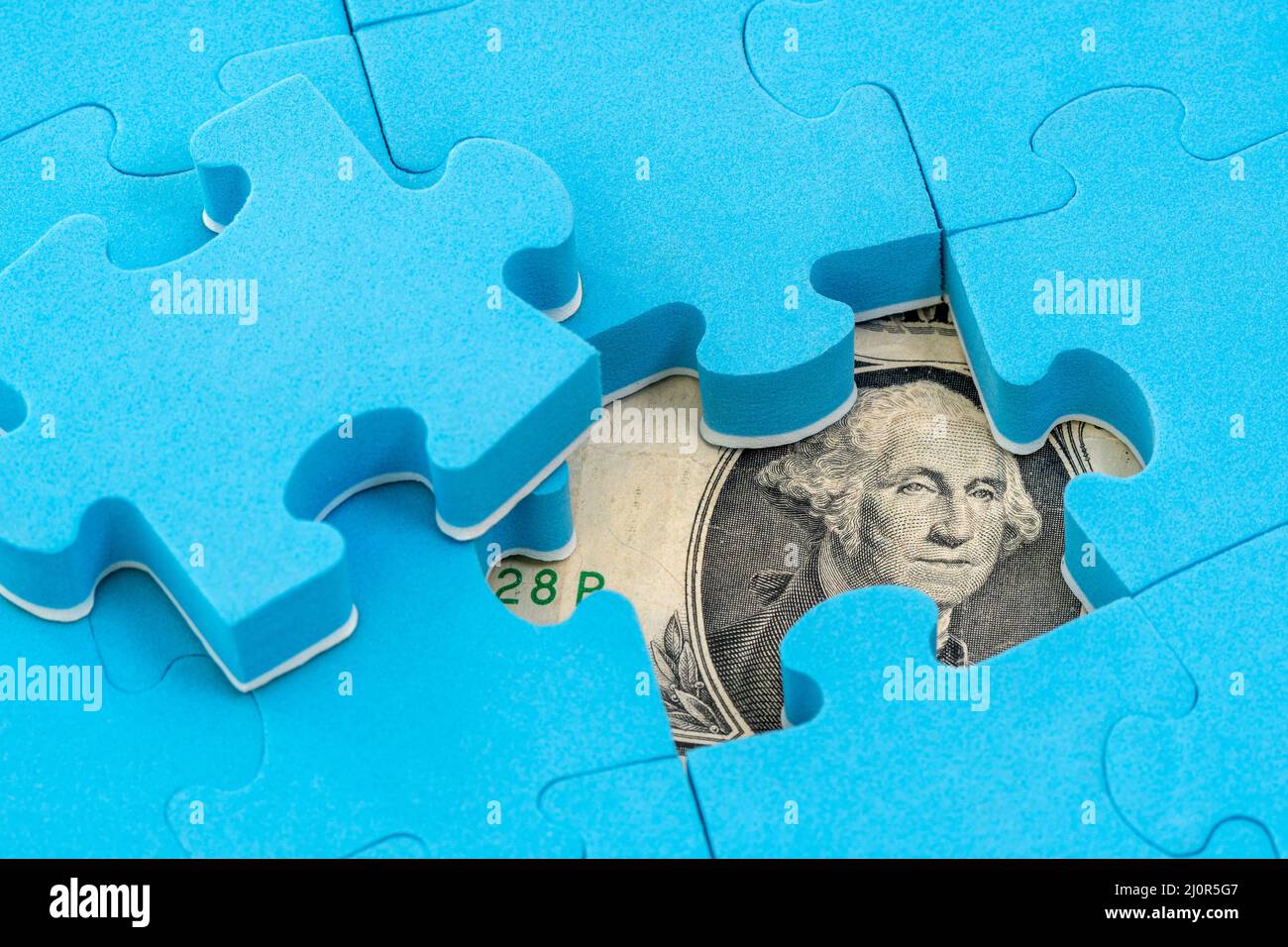 Banconota da dollaro NASCOSTA sotto il puzzle Foto Stock