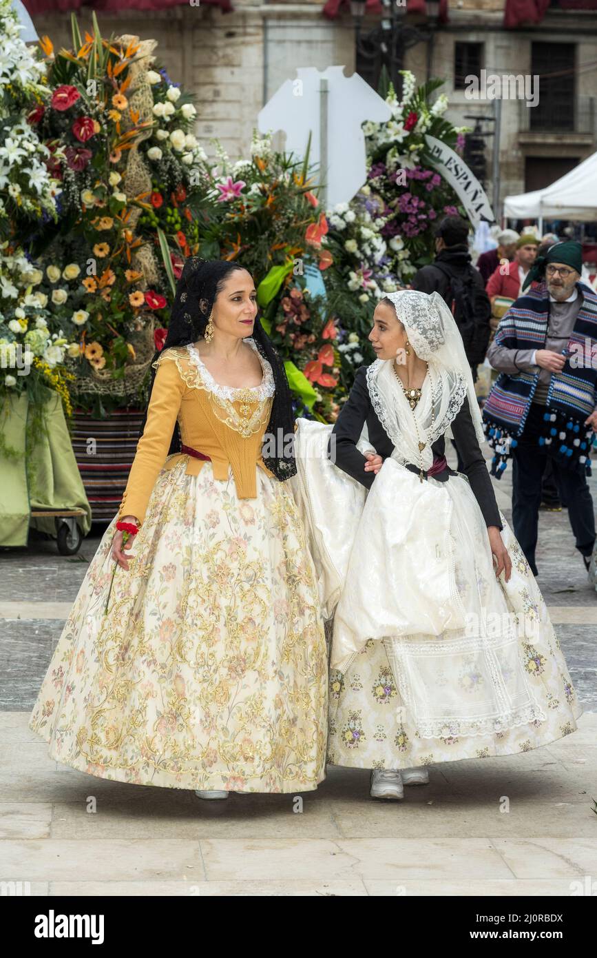 Donne falleras marching alla cerimonia di offerta dei fiori (ofrena de flors o ofrenda de flores) durante l'annuale Fallas Festival, Valencia, Spagna Foto Stock