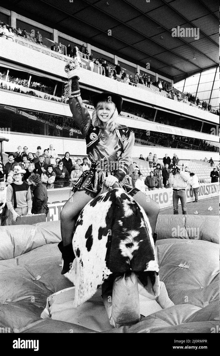 Tottenham Hotspur v Ipswich Town League match at White Hart Lane January 1984. Cowgirl offre intrattenimento pre-partita sulla macchina bucking bronco rodeo bull. Punteggio finale: Tottenham Hotspur 2-0 Ipswich Town Foto Stock