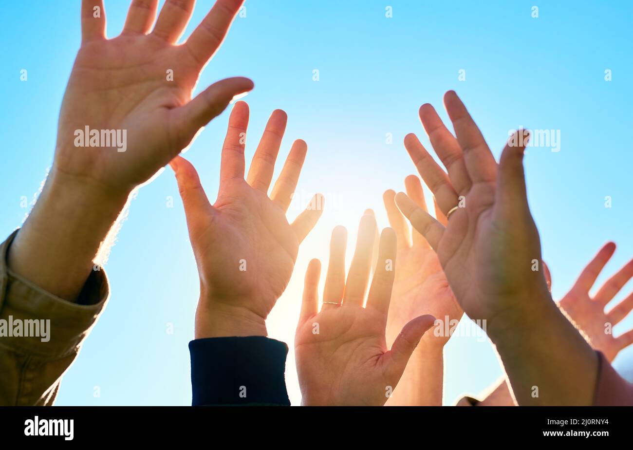 Metti le mani nell'aria e celebra la vita. Un'immagine ritagliata di un gruppo di popoli irriconoscibili si trova all'esterno. Foto Stock