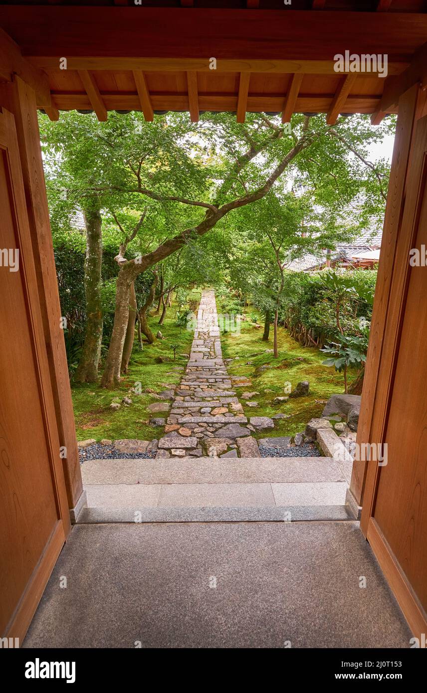 La vista attraverso il cancello di legno al giardino con la strada di pietra. Kyoto.Giappone Foto Stock