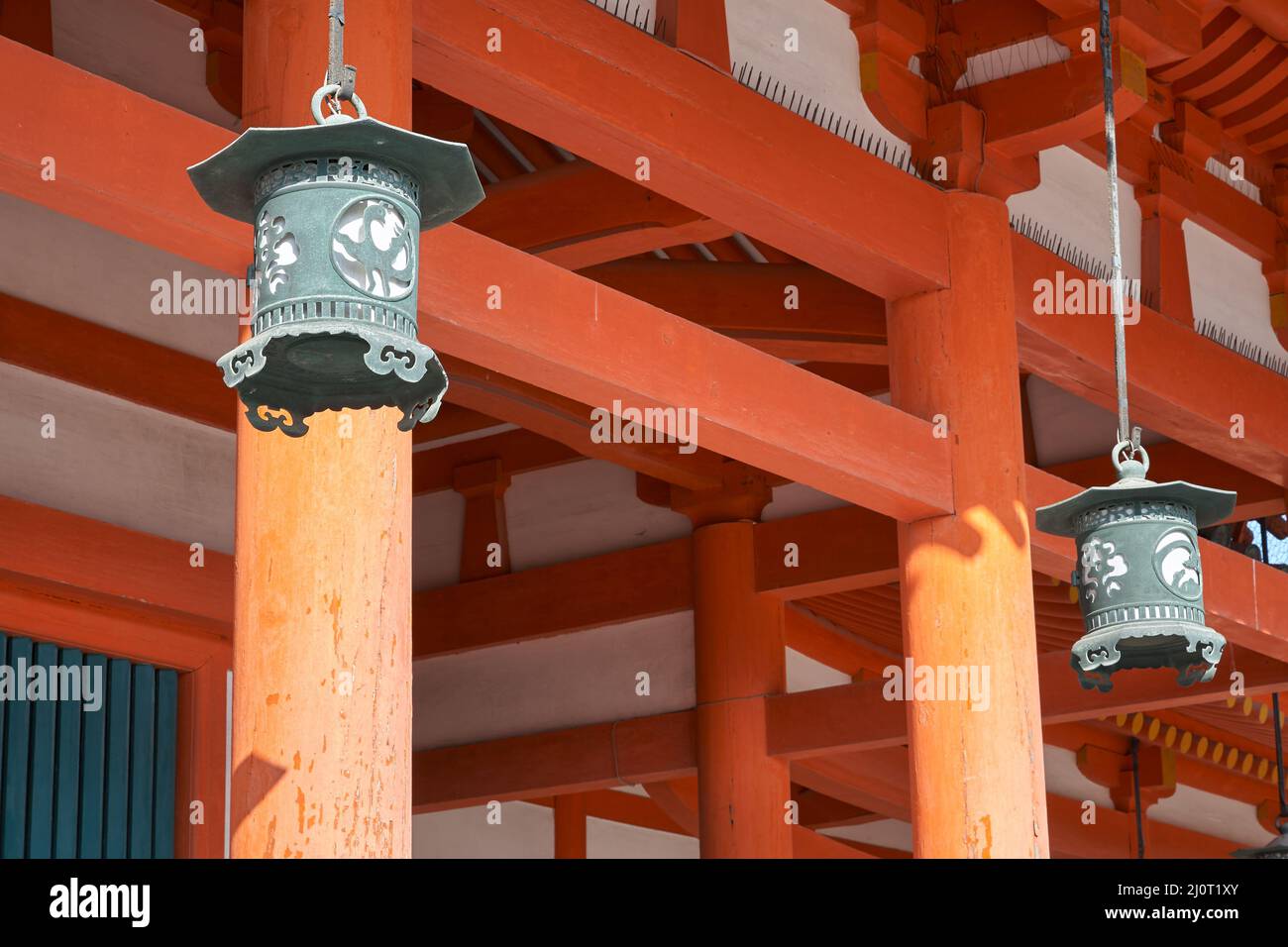 Lanterne in rame appese sullo sfondo di colonne vermilioniche. Santuario di Heian-jingu. Kyoto. Giappone Foto Stock