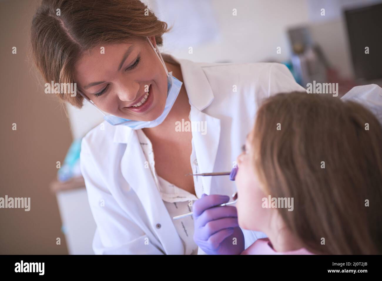 Shes altamente esperto in odontoiatria pediatrica. Scatto corto di un dentista che esamina i denti delle ragazze piccole. Foto Stock