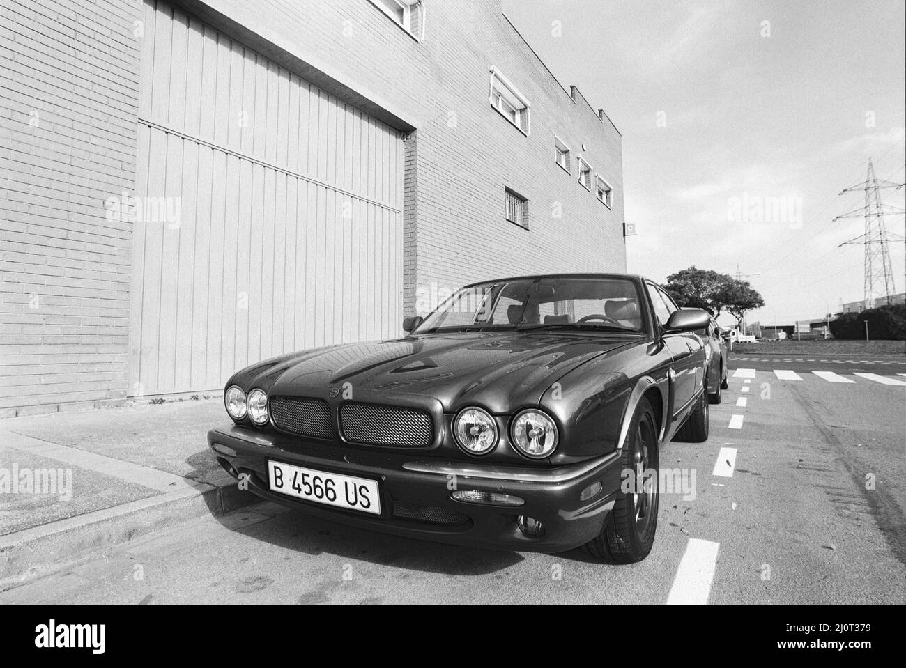 Immagine in scala di grigi di un'auto classica parcheggiata in strada, modello Jaguar XJ. Viladecans, Spagna Foto Stock