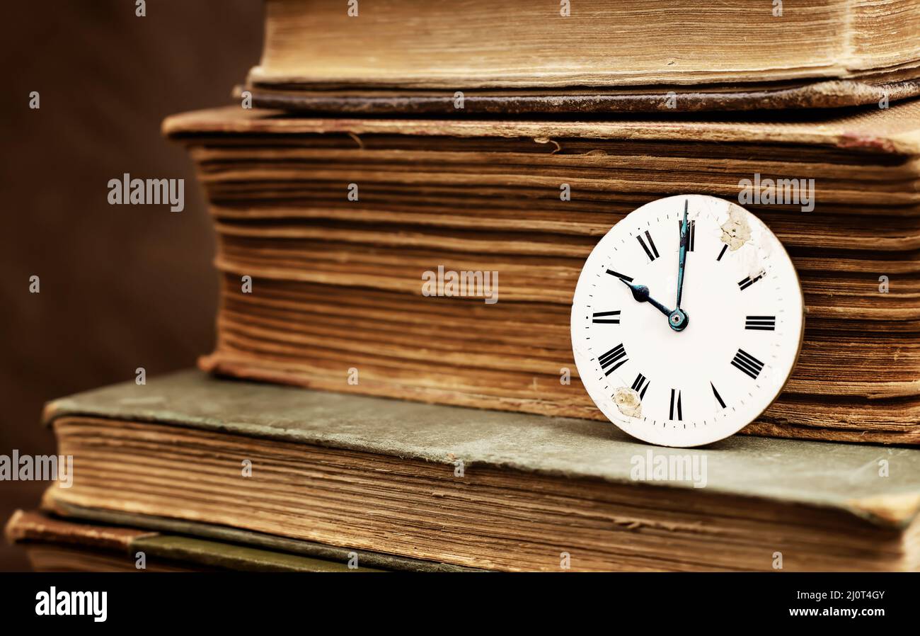 Vecchi libri e antico quadrante orologio d'epoca. Storia tempo, narrazione, sfondo passato. Foto Stock