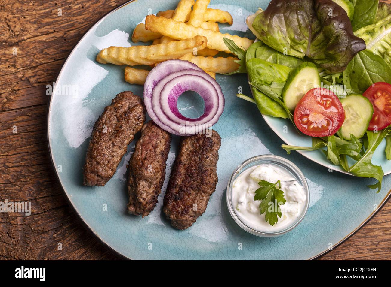 Cevapcici con patatine fritte e insalata Foto Stock