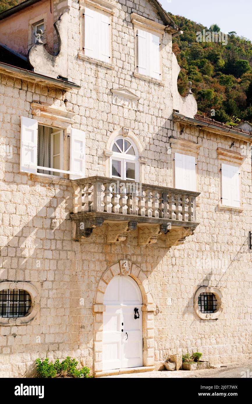 Facciata di un edificio in pietra con persiane e un balcone. Perast, Montenegro Foto Stock