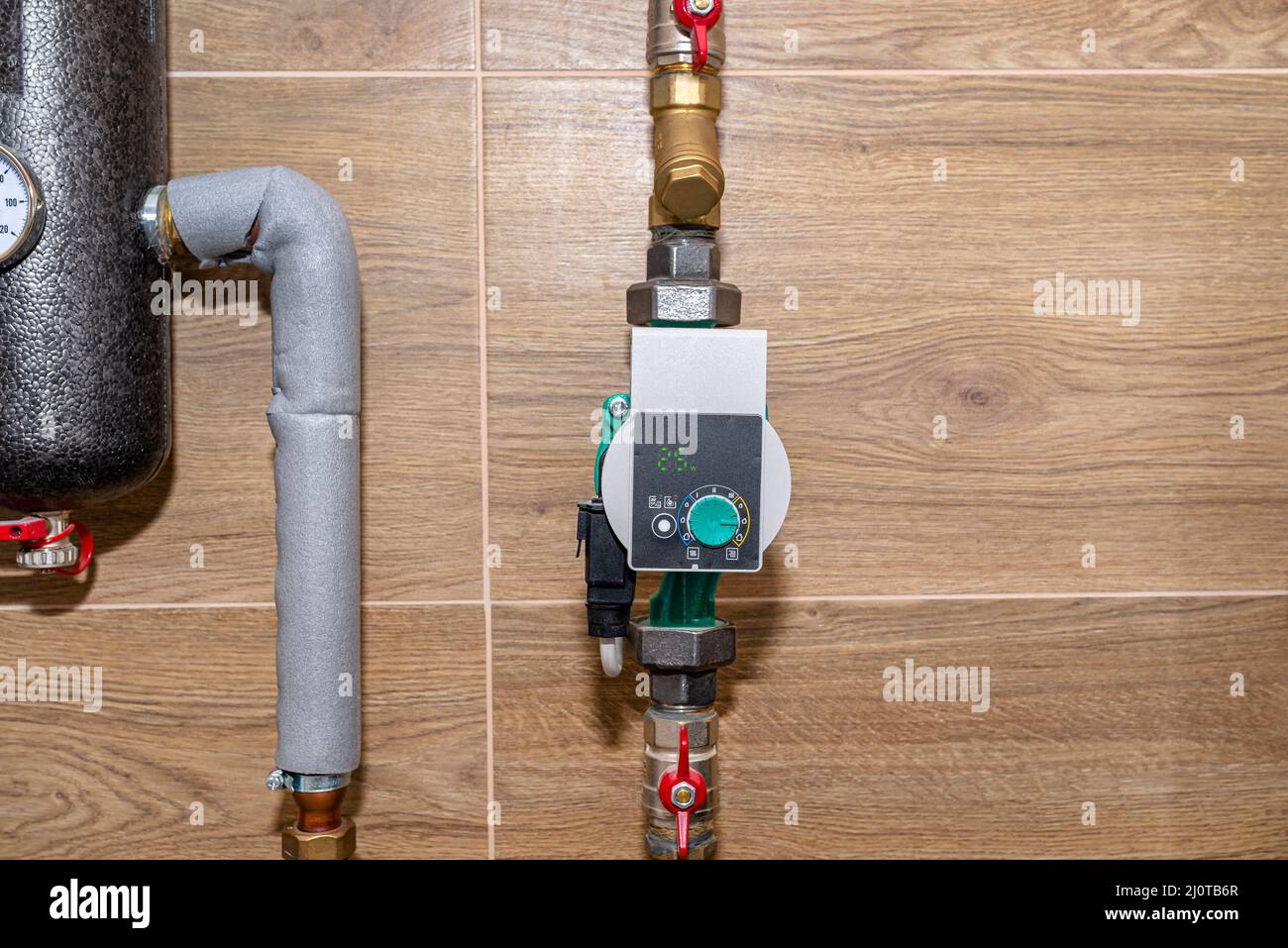 La pompa di circolazione dell'acqua per il riscaldamento a pavimento in un  moderno locale caldaia a gas rivestito di piastrelle in ceramica, mostra un  valore di 25 watt Foto stock - Alamy