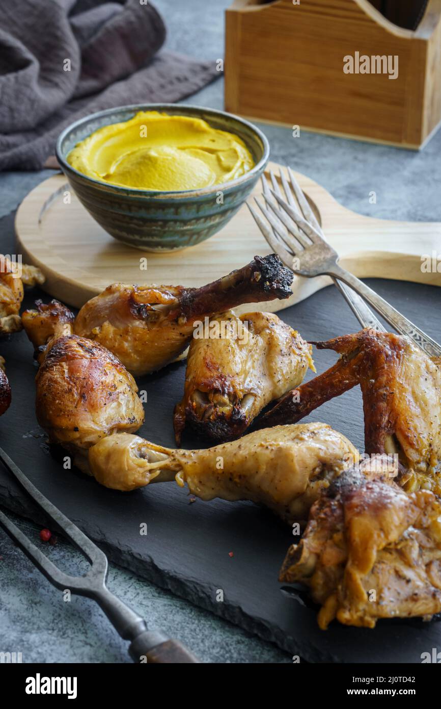 Bastoncini di pollo alla griglia e ali con salsa di senape. Messa a fuoco bassa e poco profonda Foto Stock