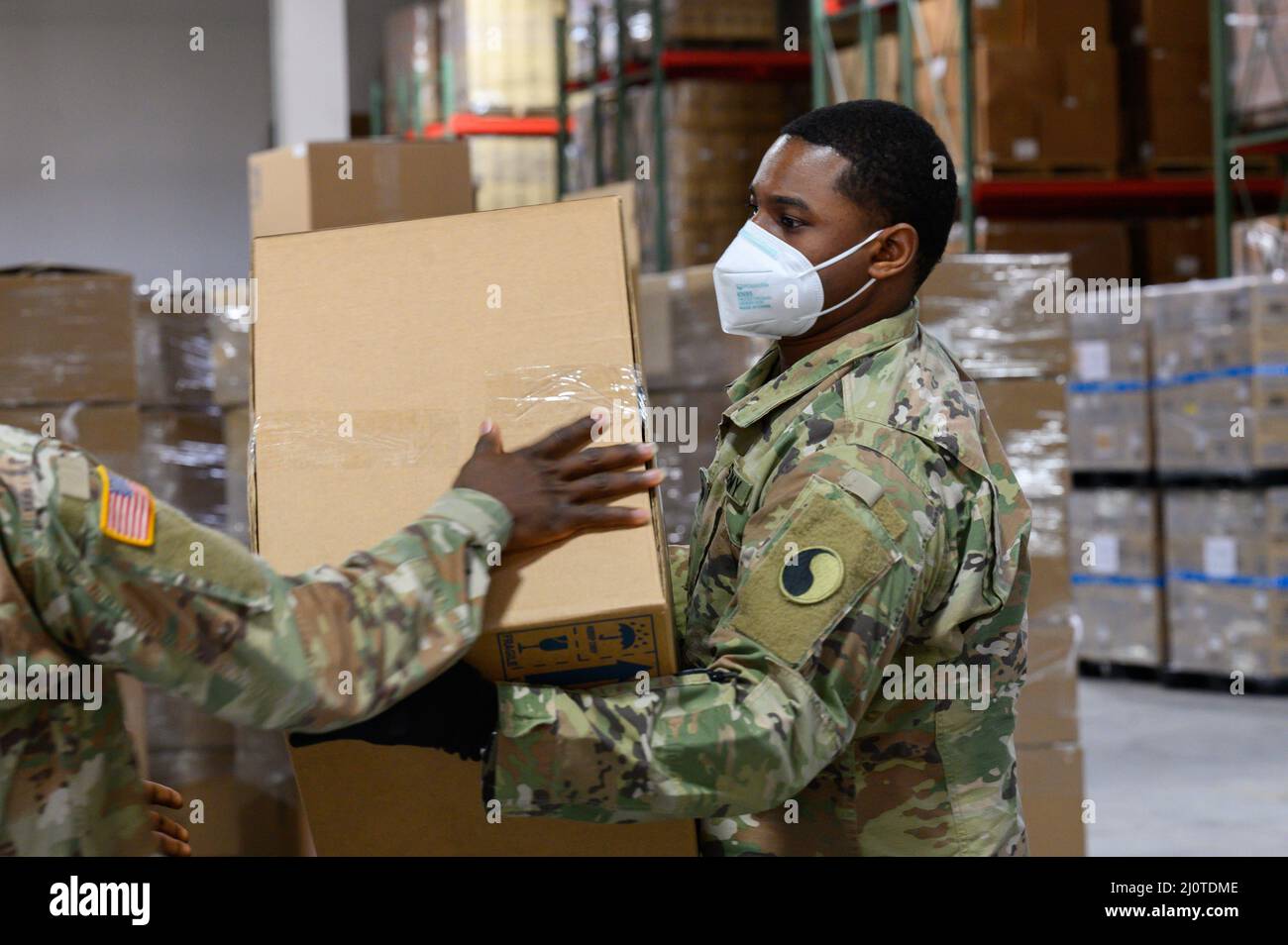 I membri della Guardia Nazionale del Maryland spostano le scatole dei kit di test COVID-19 e le maschere facciali il 24 gennaio 2022, presso la sede del Maryland Strategic National Stockpile. Alla direzione del Governatore Larry Hogan, fino a 1.000 membri del MDNG sono stati attivati per assistere gli agenti sanitari locali e statali nella loro risposta a crescenti casi e ricoveri COVID-19 per includere la distribuzione di 20 milioni di maschere KN95 e N95 e altri dispositivi di protezione personale. (STATI UNITI Foto della Guardia Nazionale dell'aria dello staff Sgt. McClanahan) Foto Stock