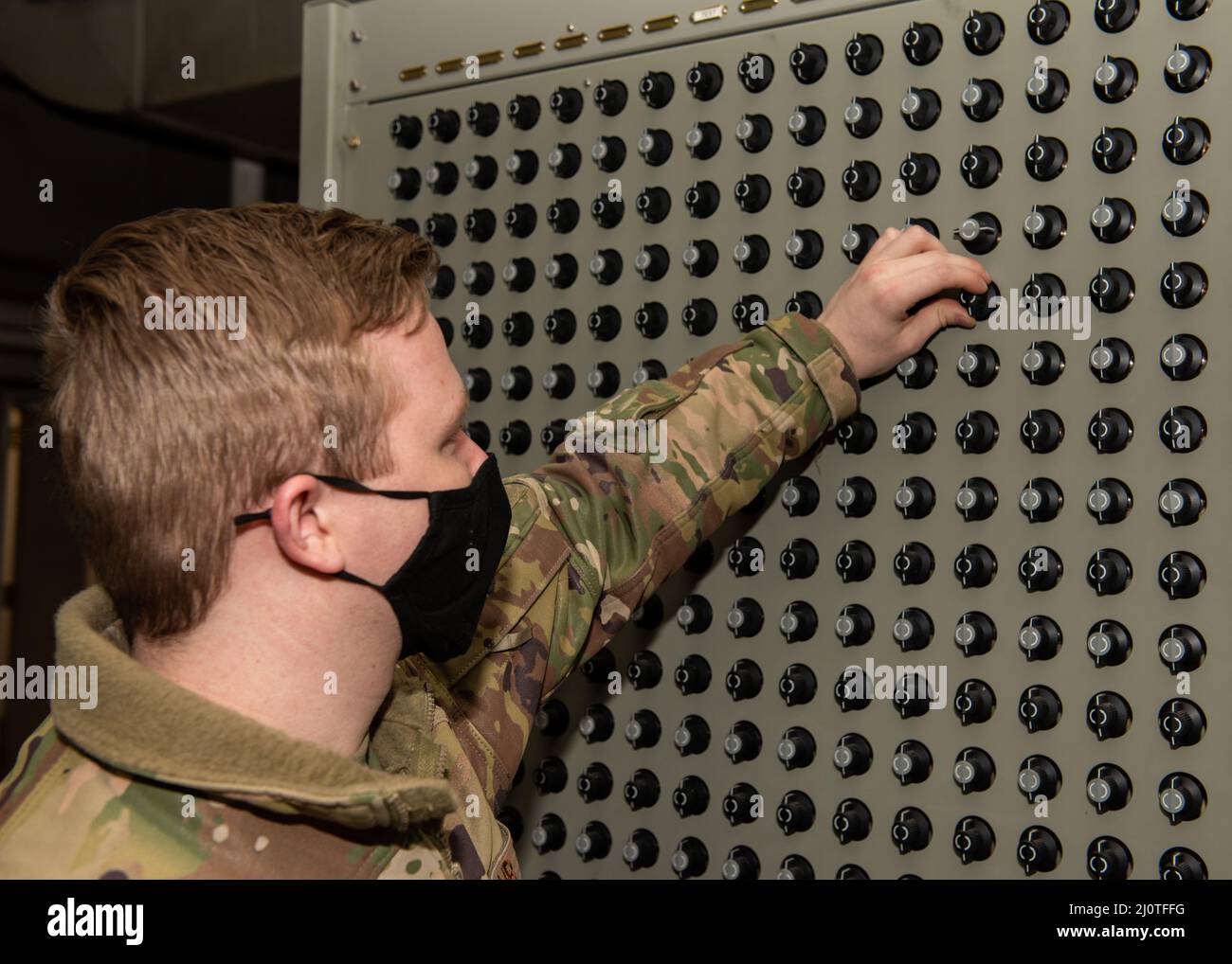 U.S. Air Force Airman 1st Class Christian Wylie, un tecnico dei sistemi di trasmissione a radiofrequenza Squadron per le comunicazioni del 673d, attiva un interruttore sulla matrice di trasmissione, creando un circuito radio che collega una radio a un'antenna presso la Joint base Elmendorf-Richardson, Alaska, 24 gennaio 2022. Gli Airmen statunitensi con il 673d CS sono stati critici per l'installazione di una torre di antenna del sistema di comunicazione globale ad alta frequenza alta 120 piedi a JBER, con i tocchi di finitura che si prevede di completare nel 2022. L'antenna è una delle 13 stazioni HFGCS dell'aeronautica statunitense, che sono strategicamente situate in tutto il mondo Foto Stock