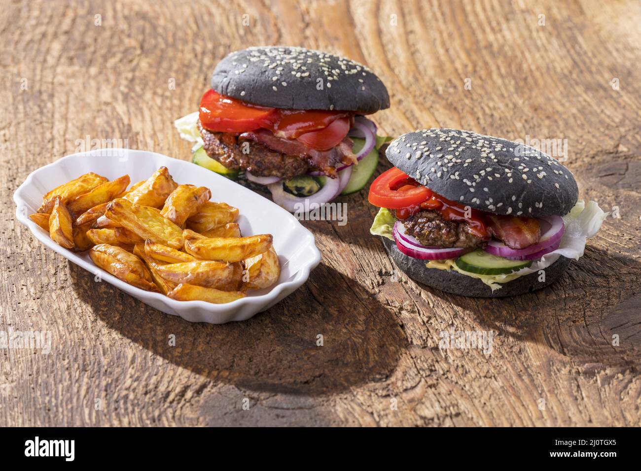 Primo piano degli hamburger neri su legno Foto Stock