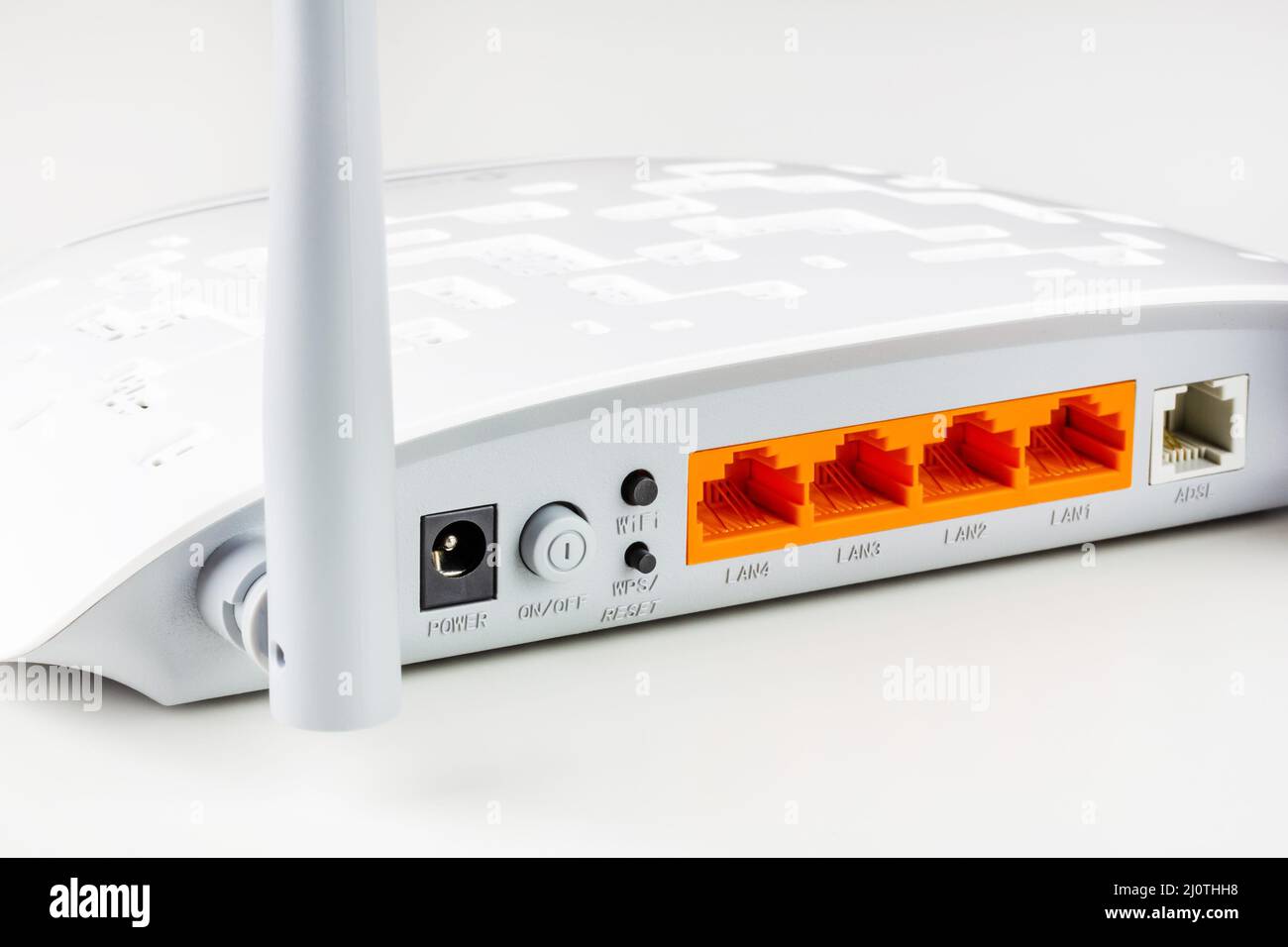 Connettori, pulsanti di controllo. Porte lan e adsl su un nuovo router Wi Fi bianco con antenne grigie su sfondo bianco in primo piano Foto Stock