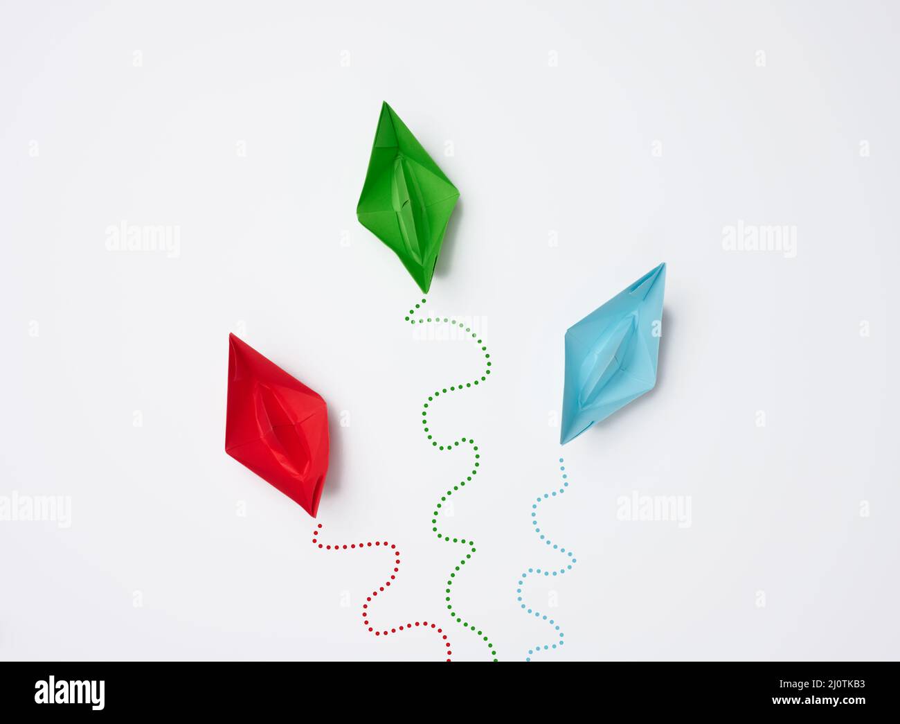 Le barche di carta si muovono in direzioni diverse su sfondo bianco. Opinioni diverse, gestione inefficace. Disunità del coll Foto Stock