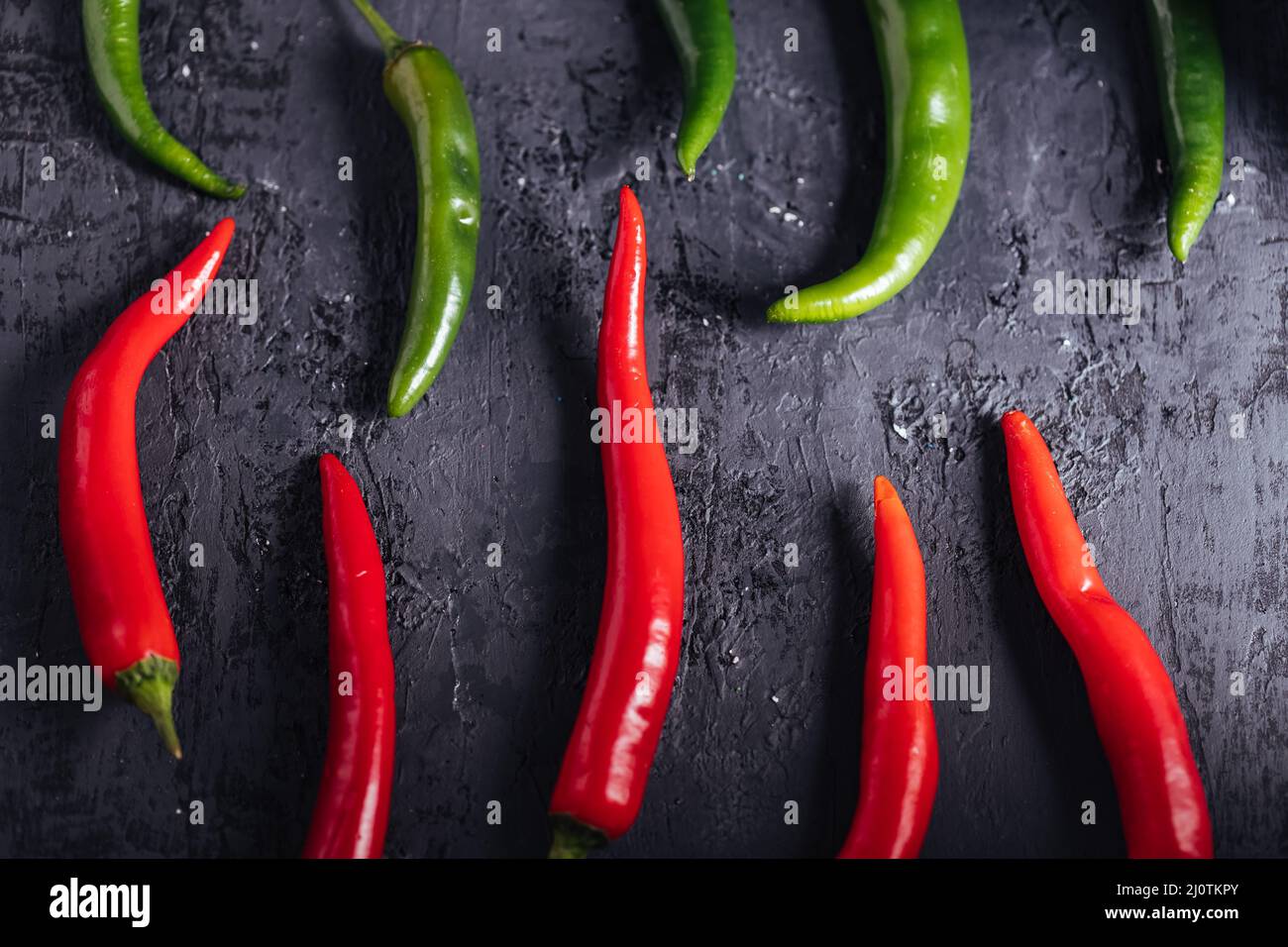 Selezione di peperoncini crudi. Gruppo di peperoni rossi e verdi. Caldo e piccante. Foto Stock