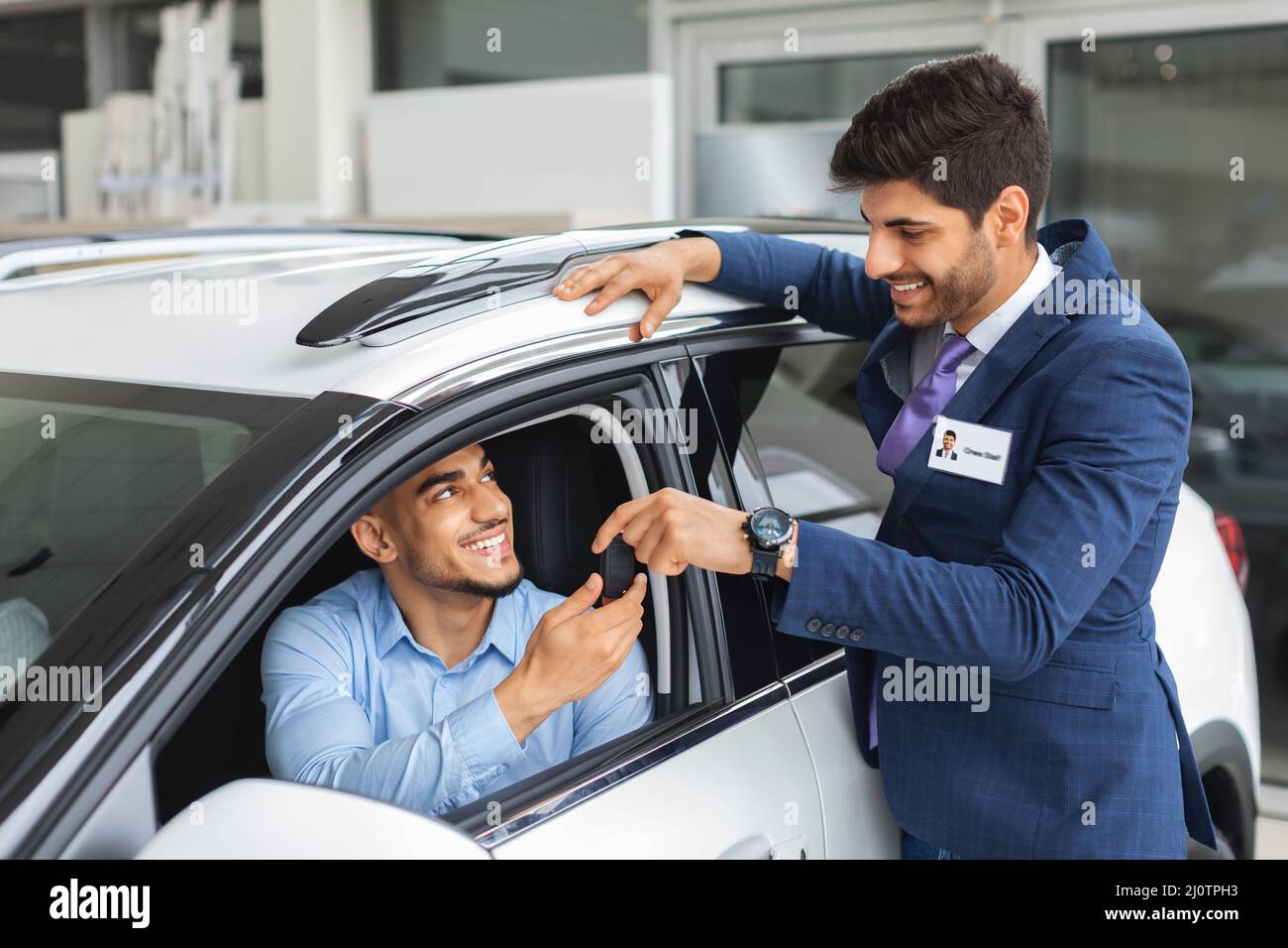 Allegro responsabile delle vendite che dà la chiave dell'auto al proprietario Foto Stock