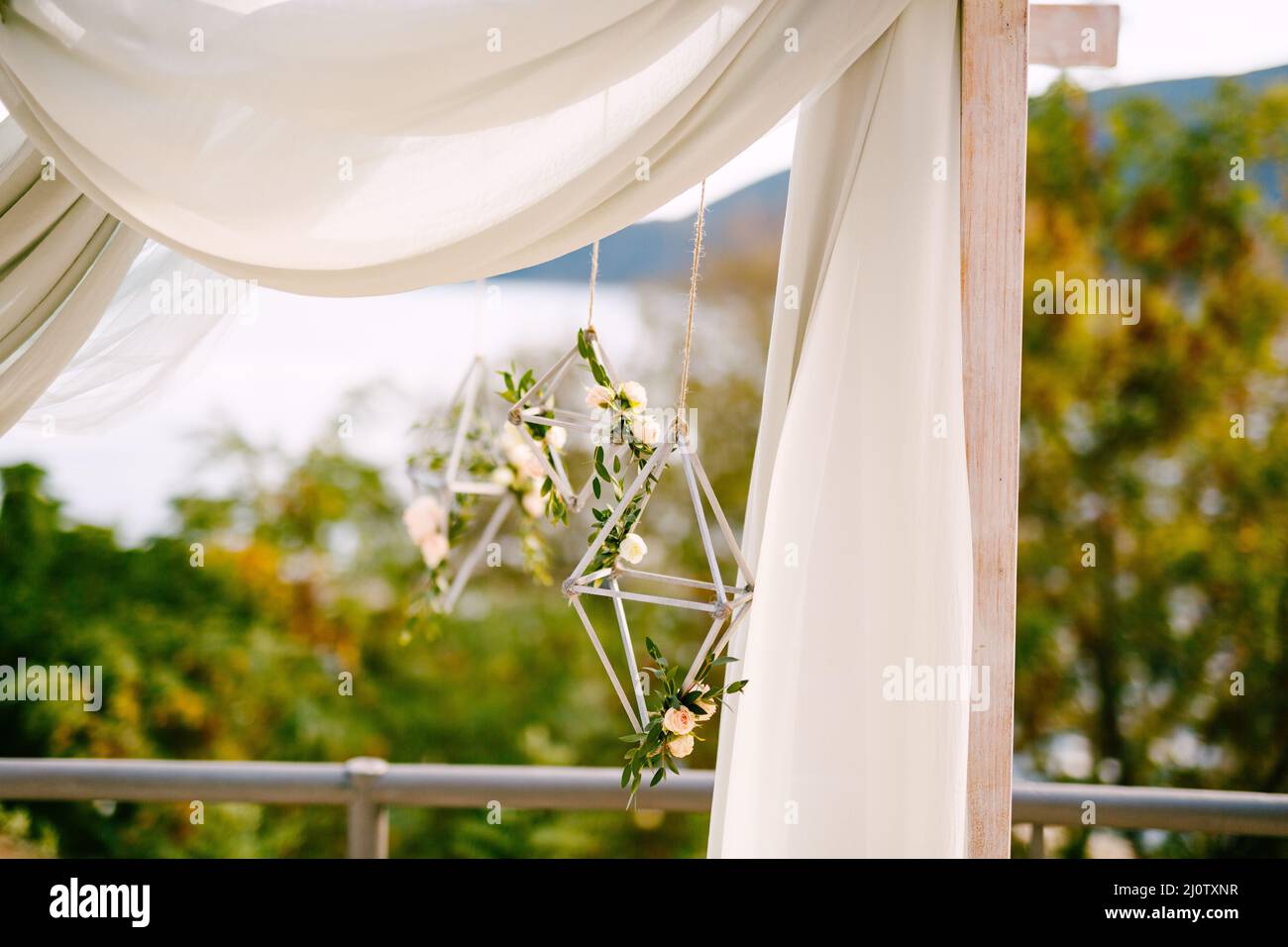 Rombo decorativo intrecciato decorato con rose da tè su un arco di nozze Foto Stock