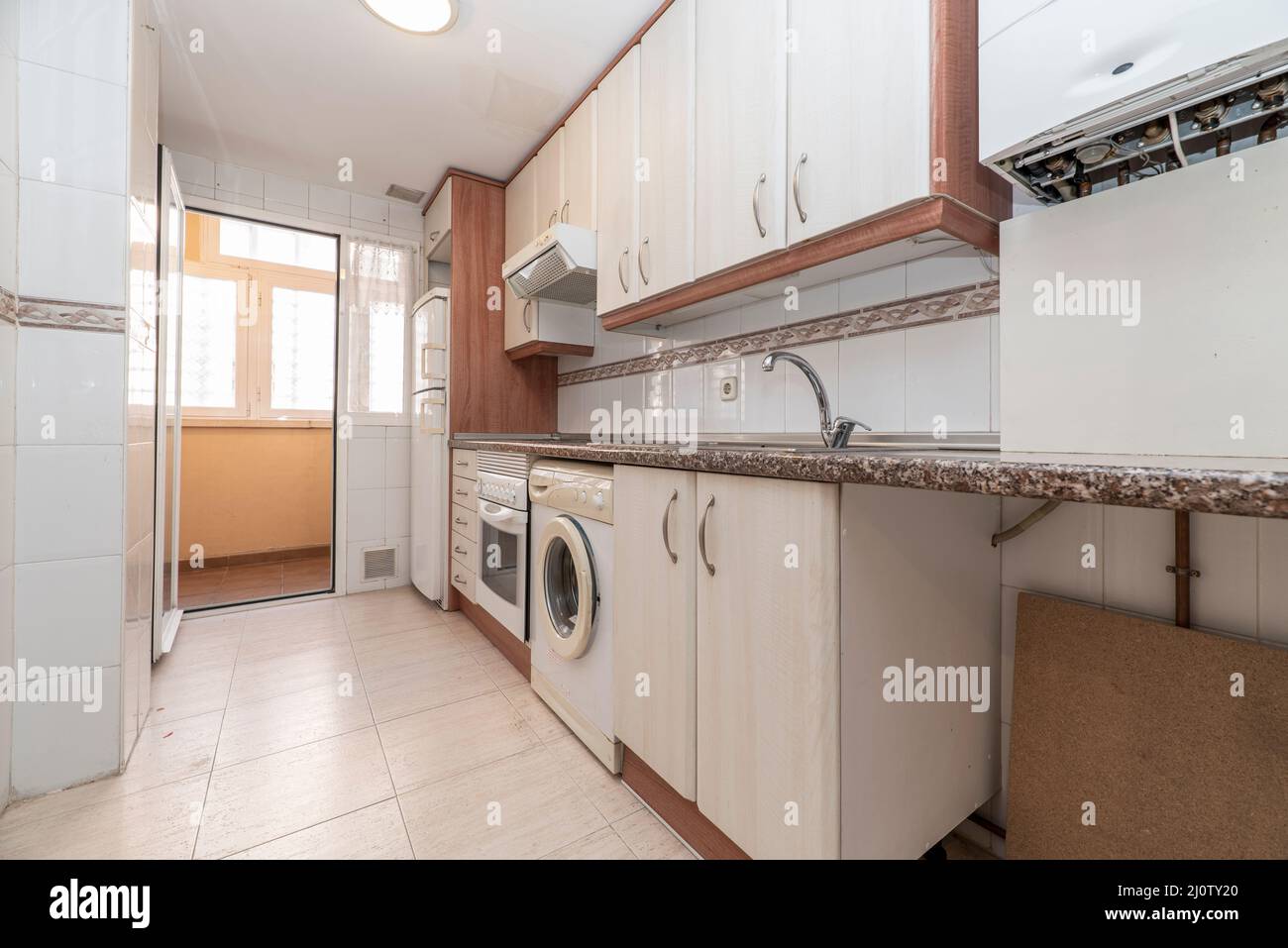 Cucina con mobili e cassetti in tonalità chiare con particolari in legno e  granito rosa con elettrodomestici bianchi e lavatrice e po Foto stock -  Alamy
