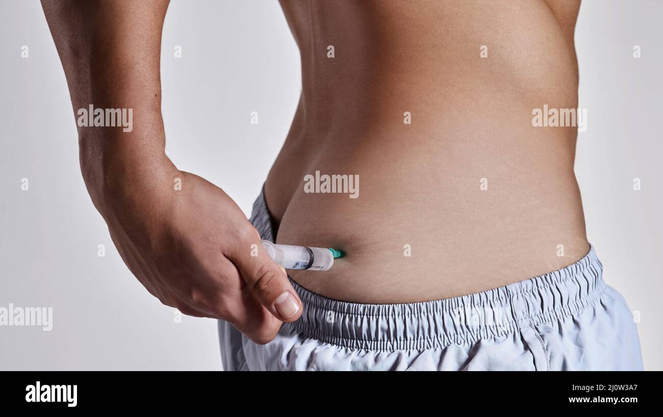 Questo mi darà la spinta di cui ho bisogno. Scatto corto di un uomo che si inietta sulla natica. Foto Stock