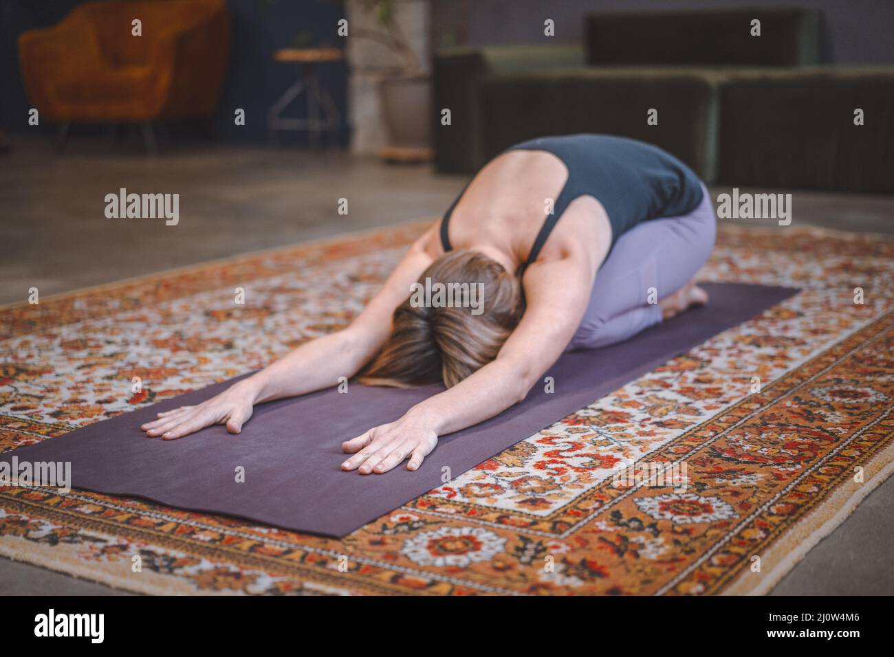 Donna Practices Yoga Asanas al mattino per l'energia per l'intera giornata. Concetto di salute, longevità, figura sottile. Primo piano Foto Stock