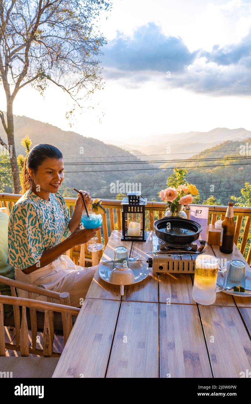 Cena nelle montagne di Chiang mai Thailandia, barbecue da tavolo, uomo asiatico utilizzando cucina pinze grigliare manzo e pancetta sul piatto griglia. Foto Stock