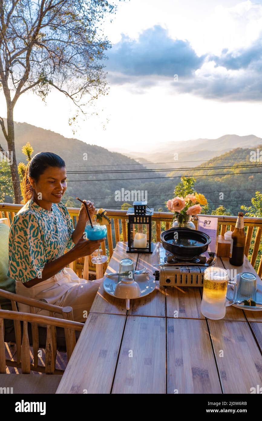 Cena nelle montagne di Chiang mai Thailandia, barbecue da tavolo, uomo asiatico utilizzando cucina pinze grigliare manzo e pancetta sul piatto griglia. Foto Stock
