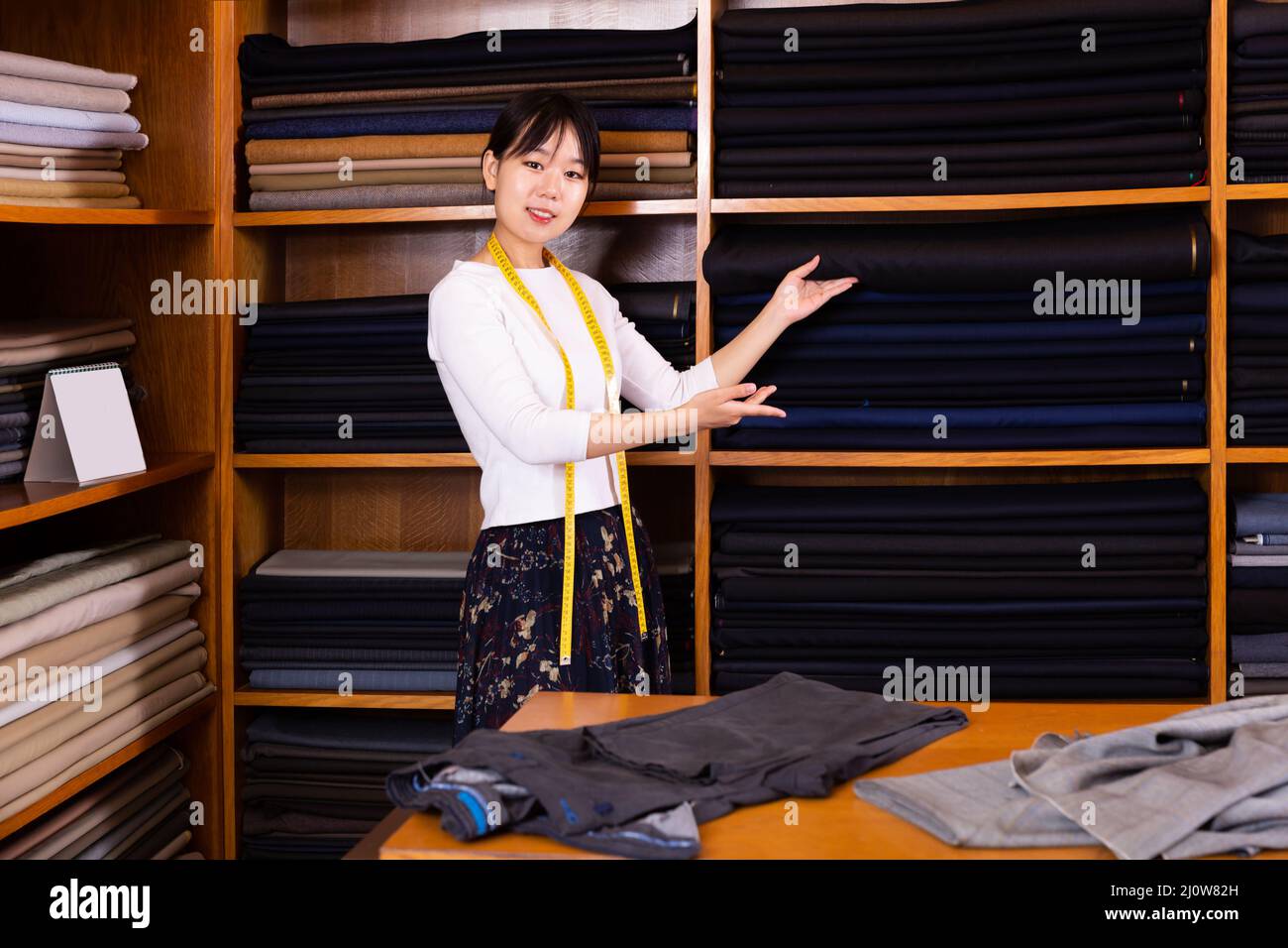 Venditore cinese adulto che lavora in negozio di tessuti Foto Stock