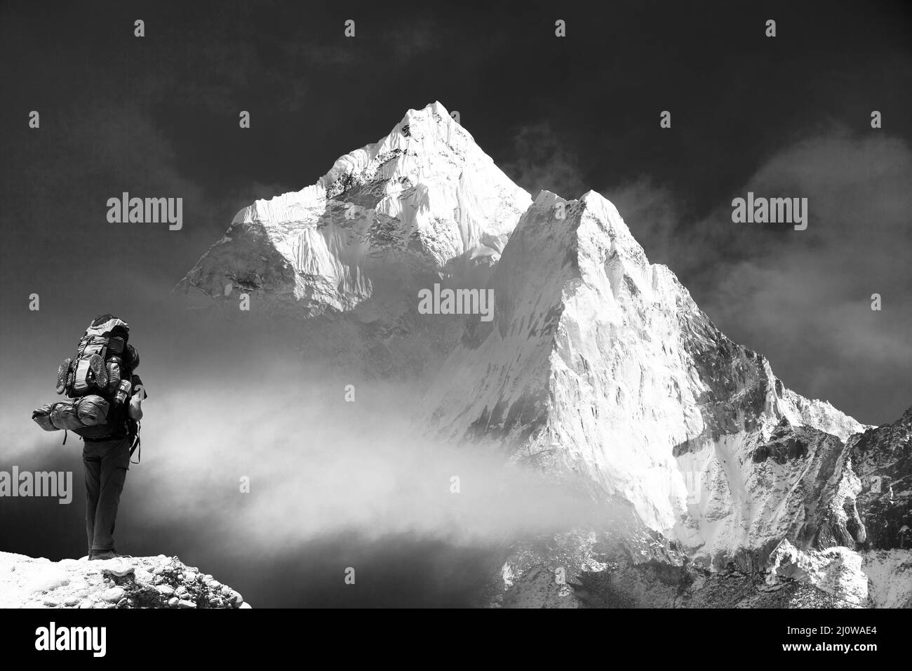 Vista serale di ama Dablam con turista - modo per il monte Everest campo base - Parco nazionale Sagarmatha - Nepal, vista in bianco e nero Foto Stock