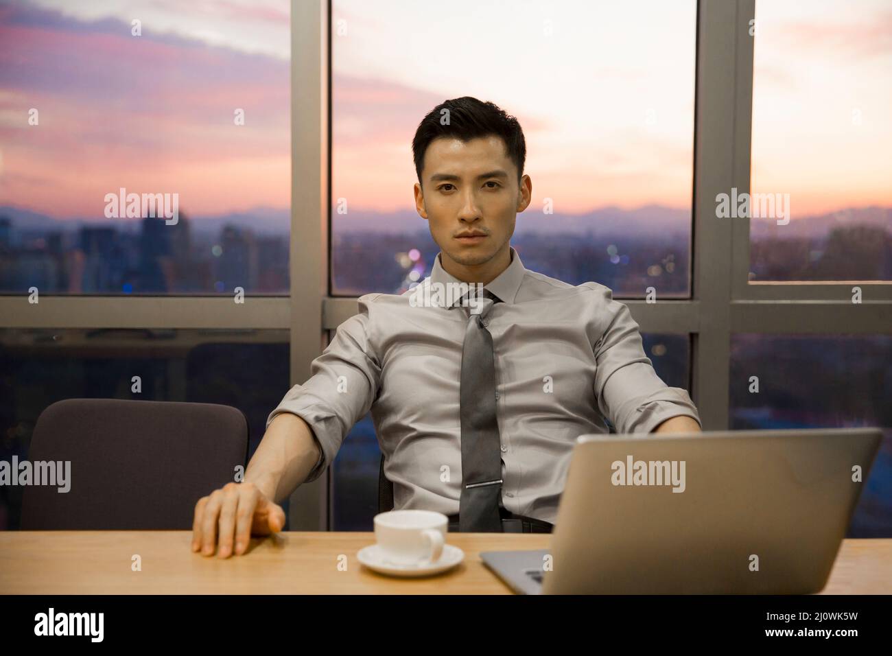 Un uomo d'affari cinese di successo che usa il computer in ufficio Foto Stock