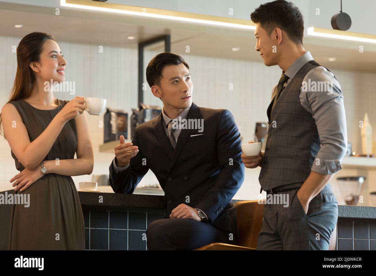 Gli uomini d'affari cinesi di successo chiacchierano nei negozi di caffè Foto Stock