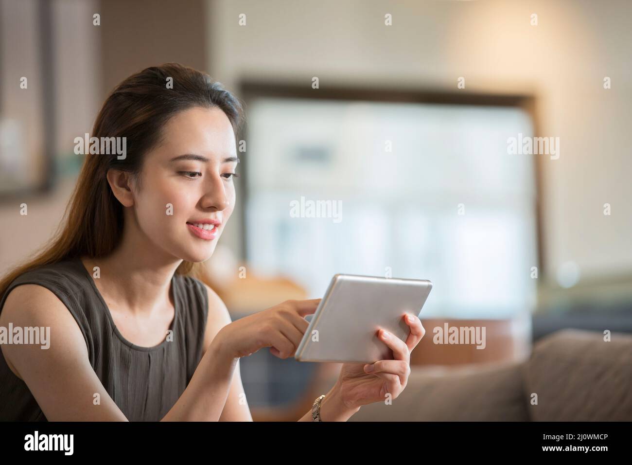 Una donna d'affari cinese di successo che lavora con un tablet digitale in un bar Foto Stock