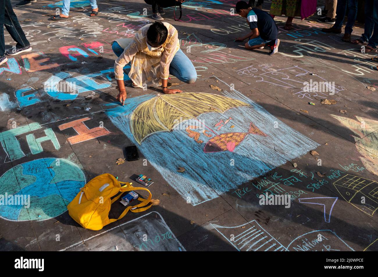 New Delhi, Delhi, India. 20th Mar 2022. Persone e bambini partecipano a una Street art. Chalk Graffiti, come parte di un'iniziativa di sensibilizzazione relativa al cambiamento climatico per il futuro per i venerdì a Connaught Place a Nuova Delhi. (Credit Image: © Mohsin Javed/Pacific Press via ZUMA Press Wire) Foto Stock