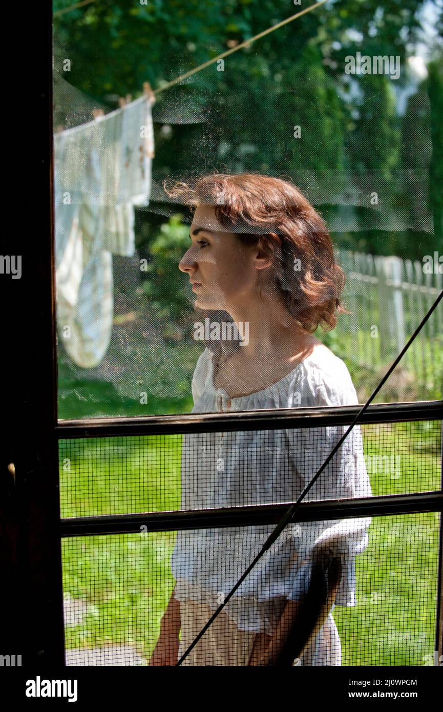 Giovane donna attraverso lo schermo porta Foto Stock