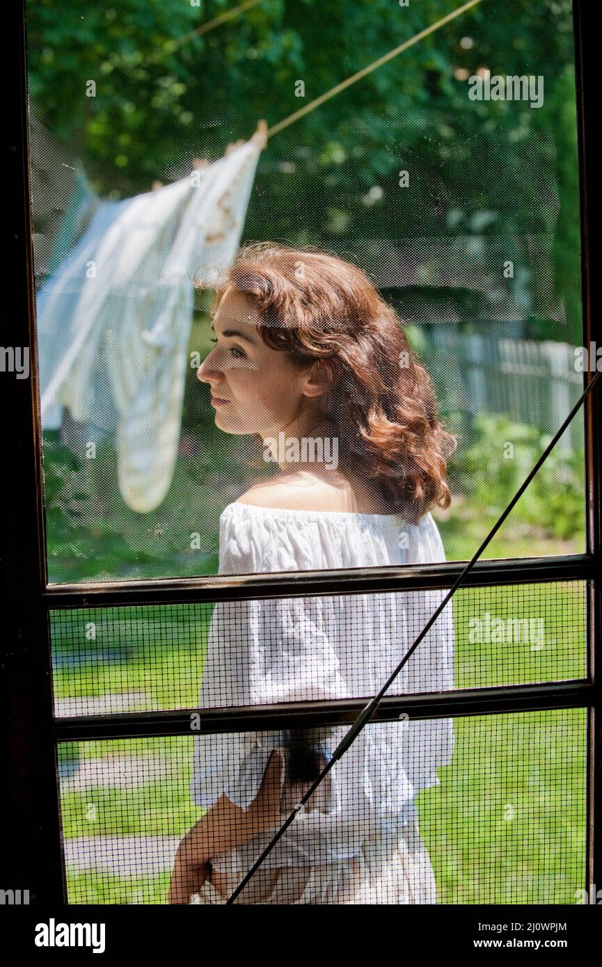 Giovane donna attraverso lo schermo porta Foto Stock