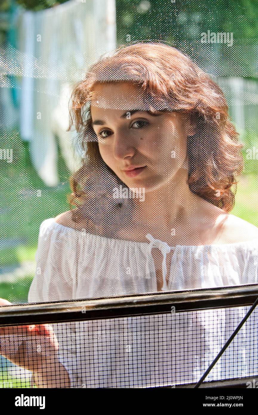 Giovane donna attraverso lo schermo porta Foto Stock